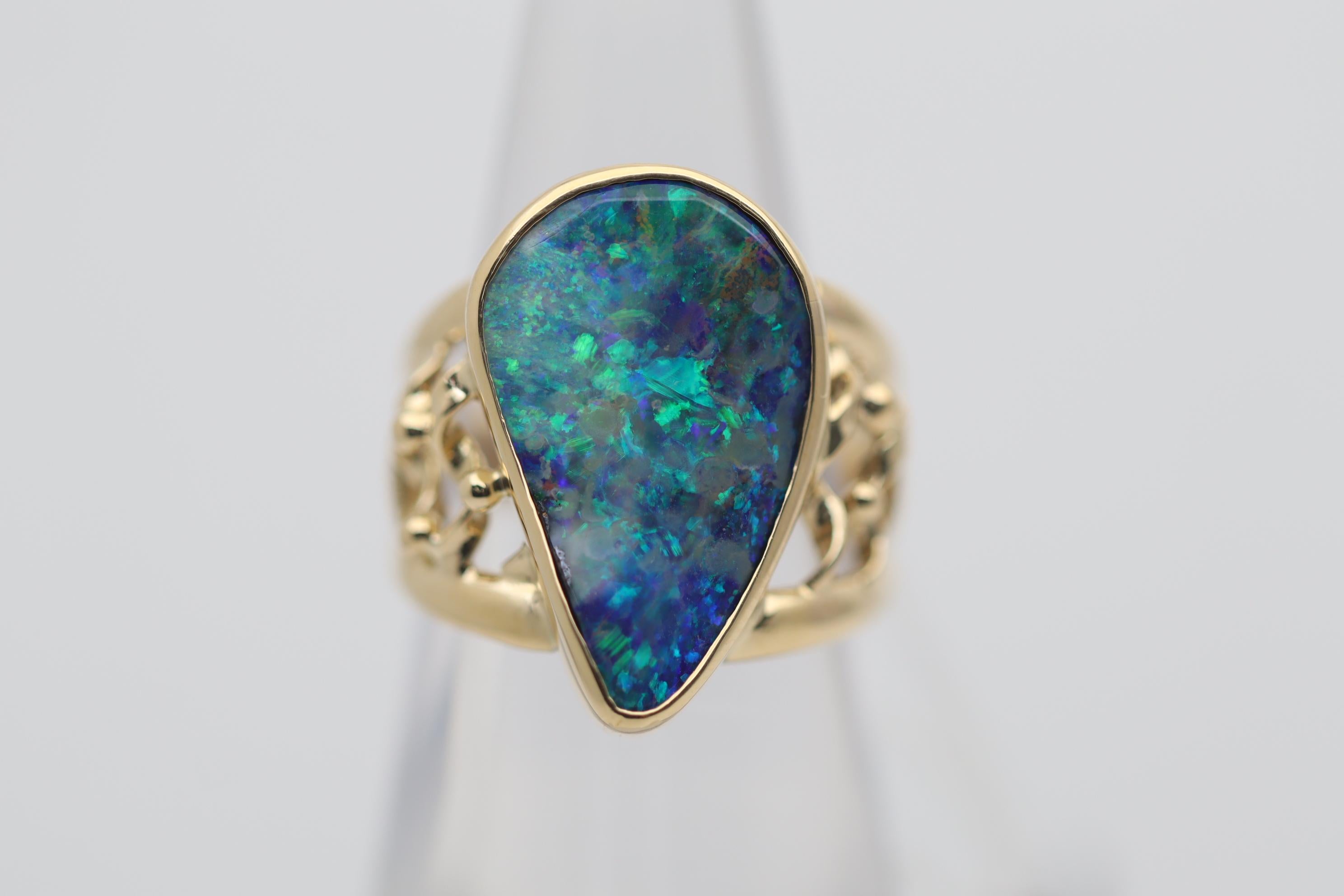Une bague en or amusante et élégante, ornée d'une opale australienne de 8,09 carats ! L'opale est une opale naturelle de type boulder et présente un grand jeu de couleurs avec une gamme éblouissante de bleus et de verts. Making Works en or jaune 18