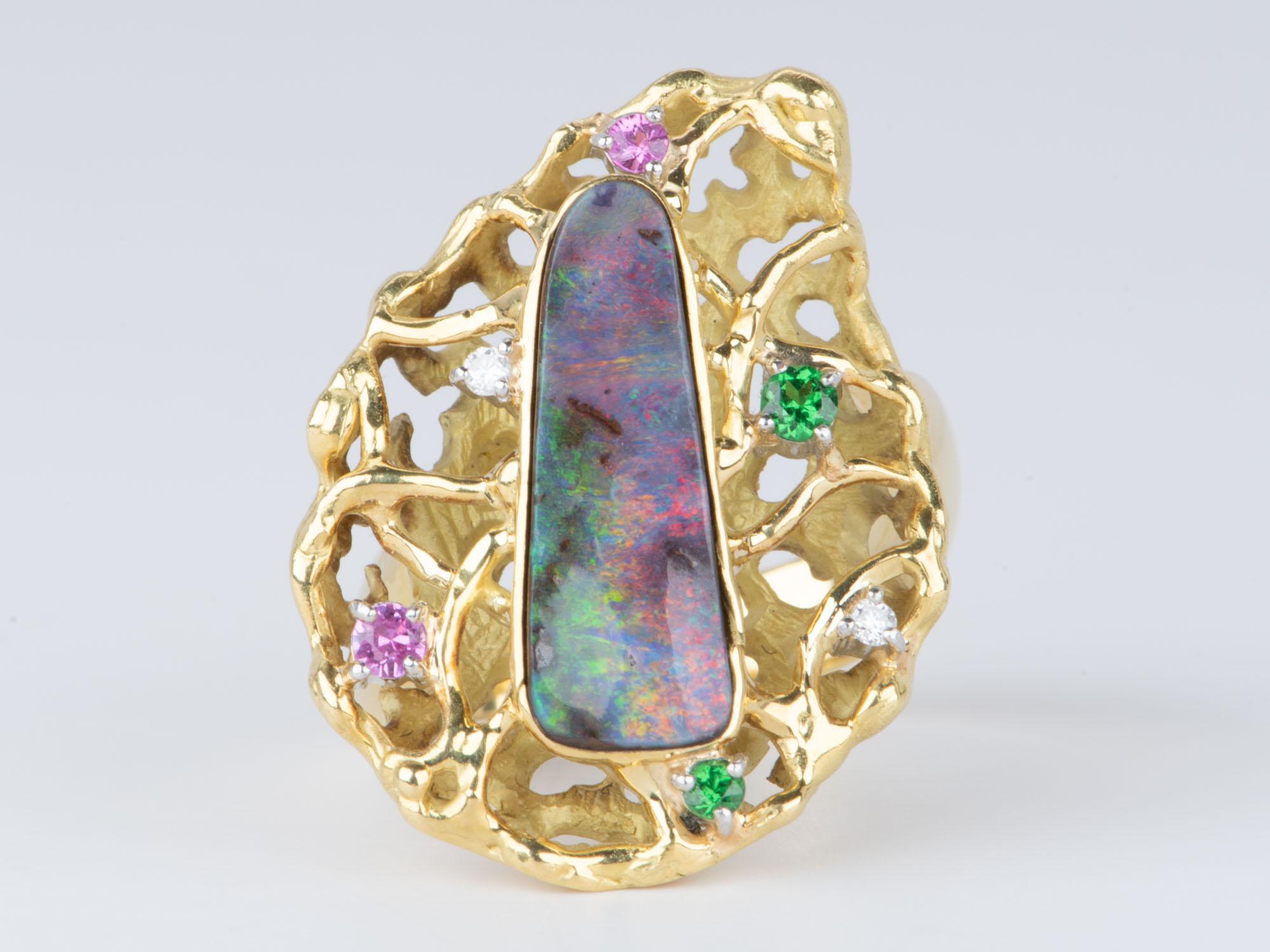 Dieser exquisite Ring ist aus einem einzigartigen australischen Boulder-Opal gefertigt, der in einen modernistischen, organischen Blumenkopf aus massivem 18-karätigem Gold eingefasst ist. Das farbenfrohe und verschlungene Design ist perfekt für
