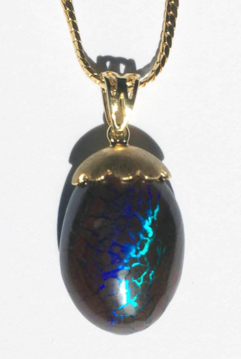 This is an amazing piece resembling a magical Dinosaur egg capped with a brushed 18kt Gold bail. This 15.35 Carat Australian Boulder Opal has intense fire, ranging in color from Violet to deep Blue to extra vivid Teal Green. In the featured video,