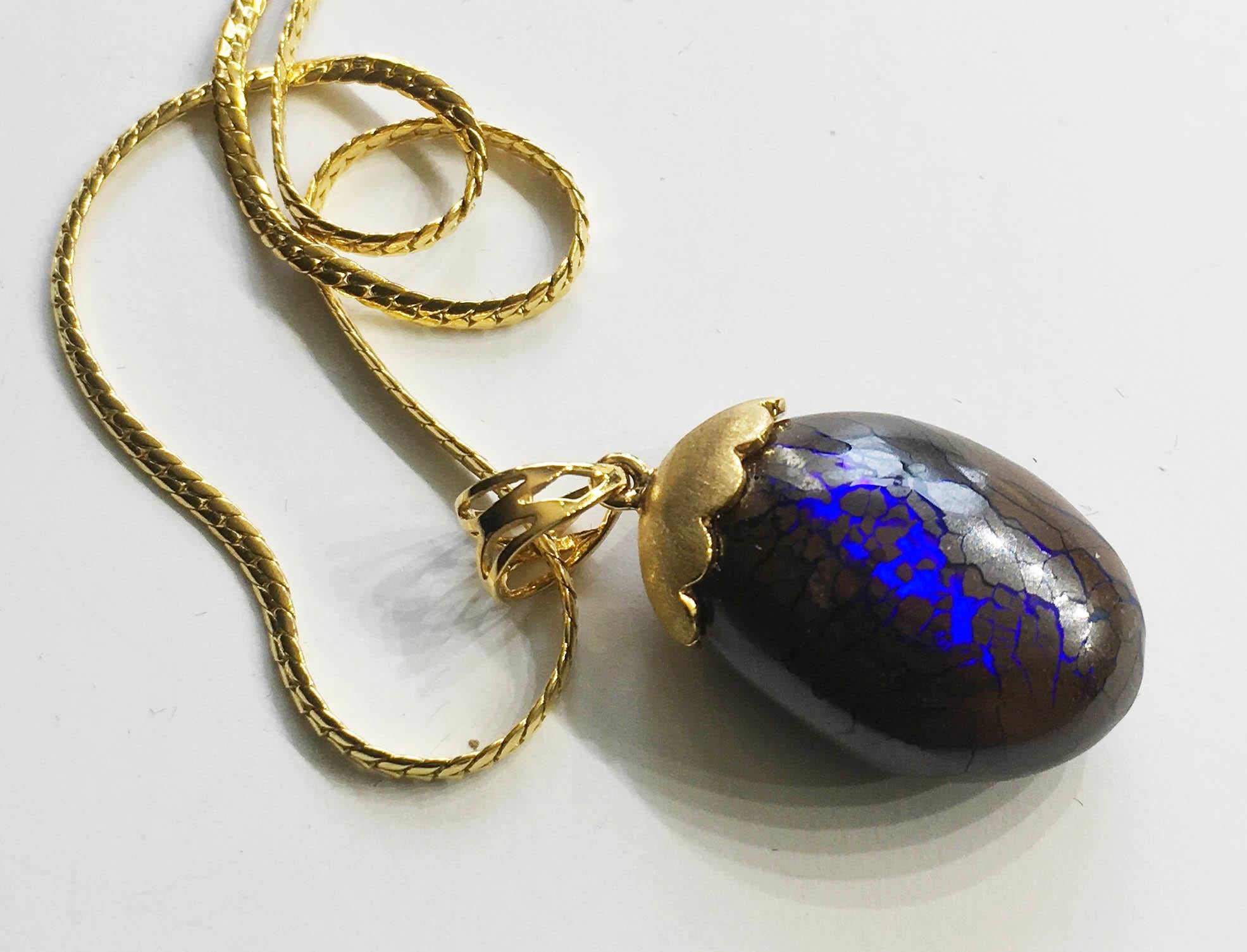 Cabochon Australian Boulder Opal Pendant Hanging from a 23kt Gold Necklace