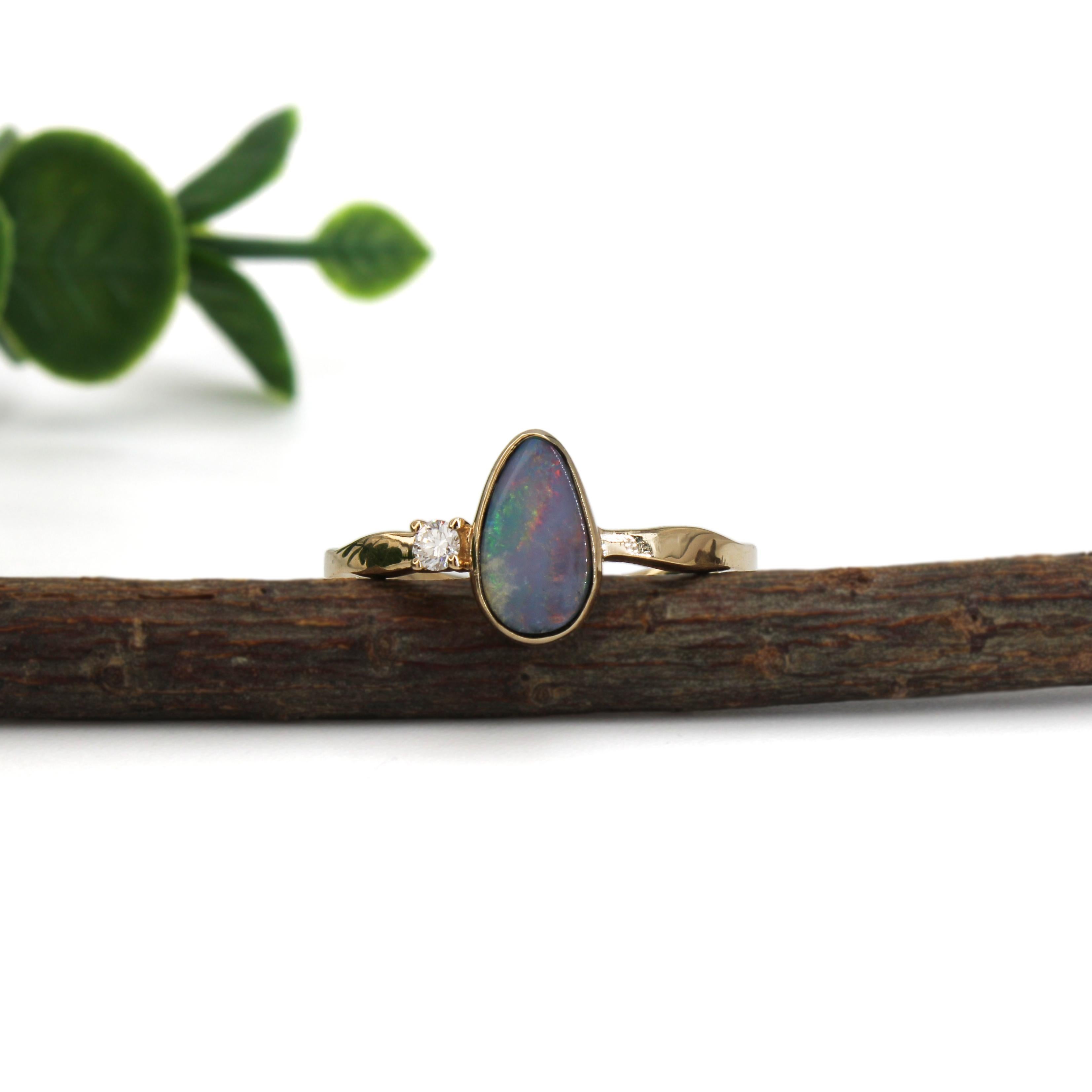 Dieser handgefertigte Ring aus 14-karätigem Gelbgold zeigt einen auffälligen Boulder-Opal, der durch sein natürliches Farbspiel besticht. Das asymmetrische Band und die Lünettenfassung unterstreichen den modernen Charakter, während ein einzelner