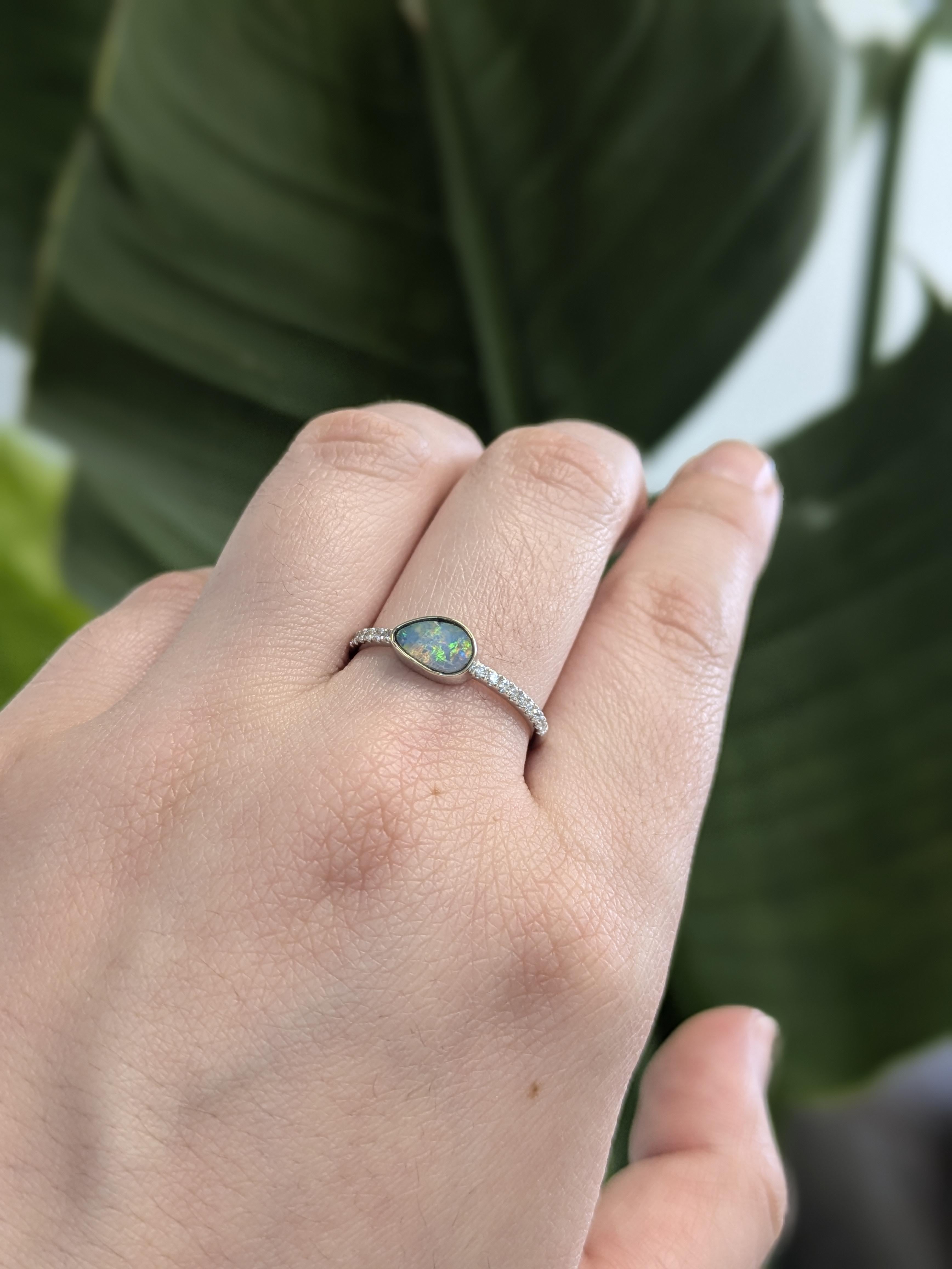 A slice of Australian magic. A dreamy 0.62 carat boulder opal takes center stage, framed by twinkling earth-mined diamonds in a pavé setting — all set in solid 14k white gold. Sleek, rare, unforgettable.

**We offer complimentary resizing, message