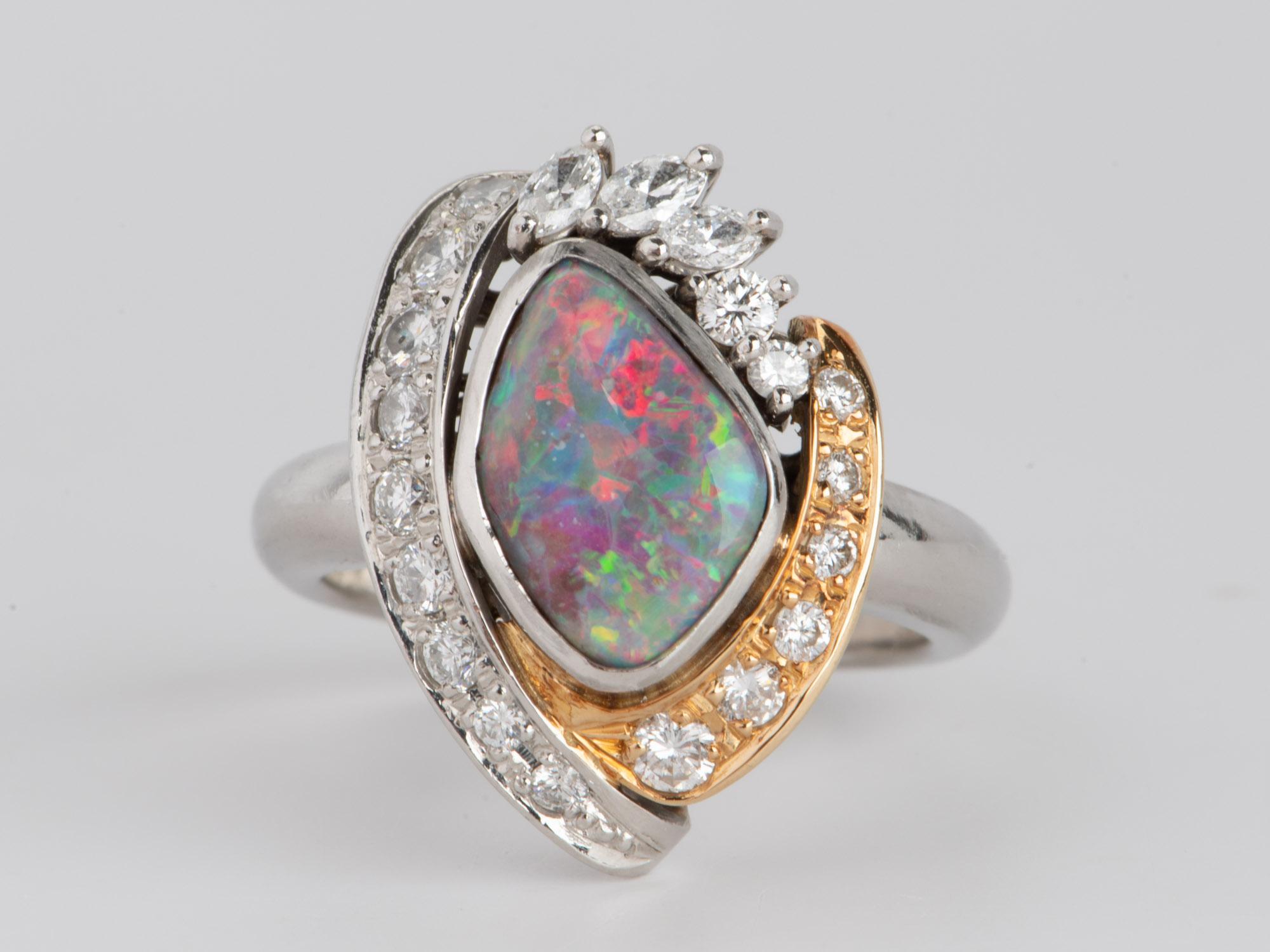 This stunning Australian Boulder Opal Ring is made from 18K Gold and Platinum and is a statement-making piece of jewelry. Its impressive craftsmanship features an impressive natural boulder opal with bright red and green flashes, designed to glitter