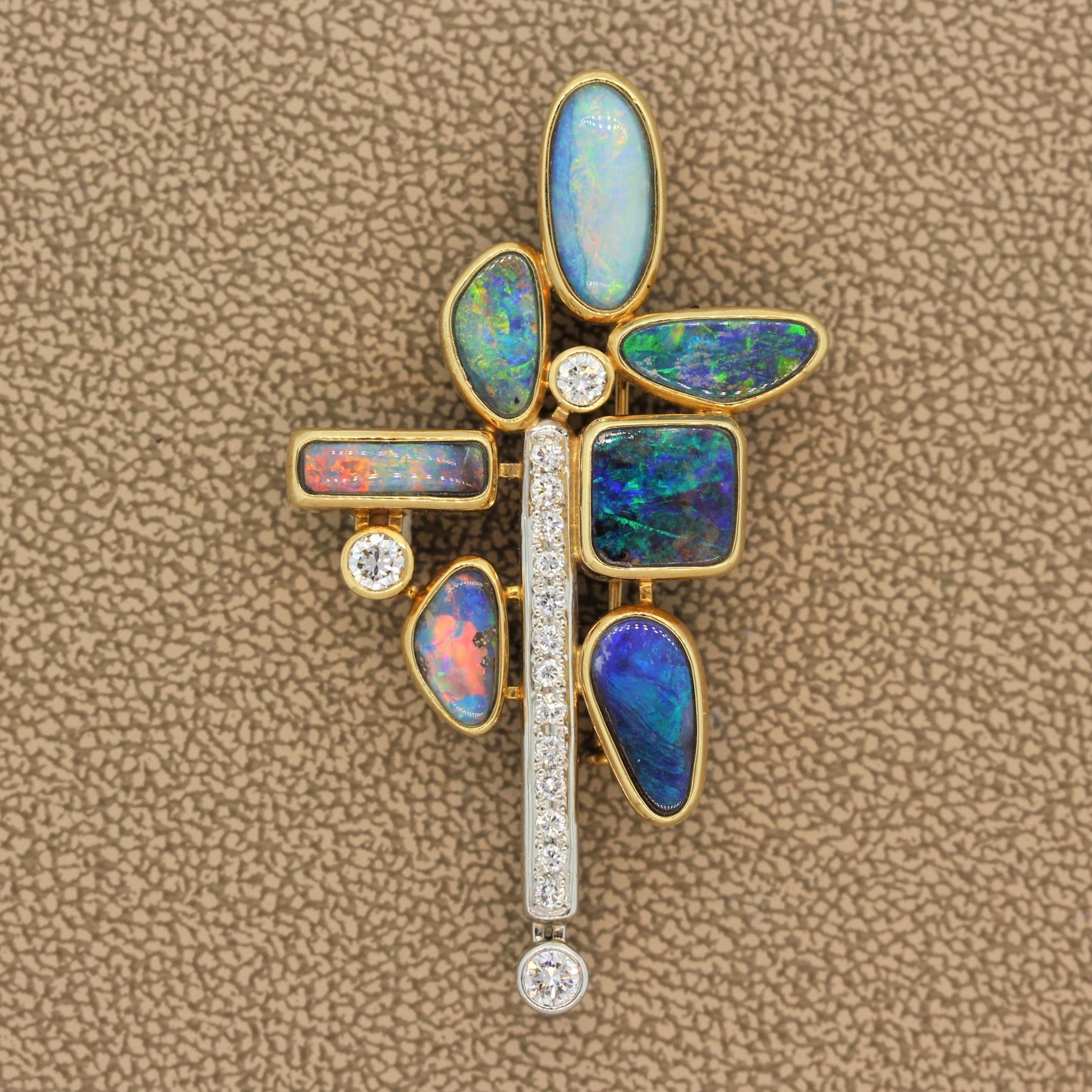This one of a kind brooch features seven pieces of fine boulder opal in an 18K yellow gold setting. The bezel set opals all show amazing play of color with flashes of red green and blue. They are accented by colorless diamonds which are set in