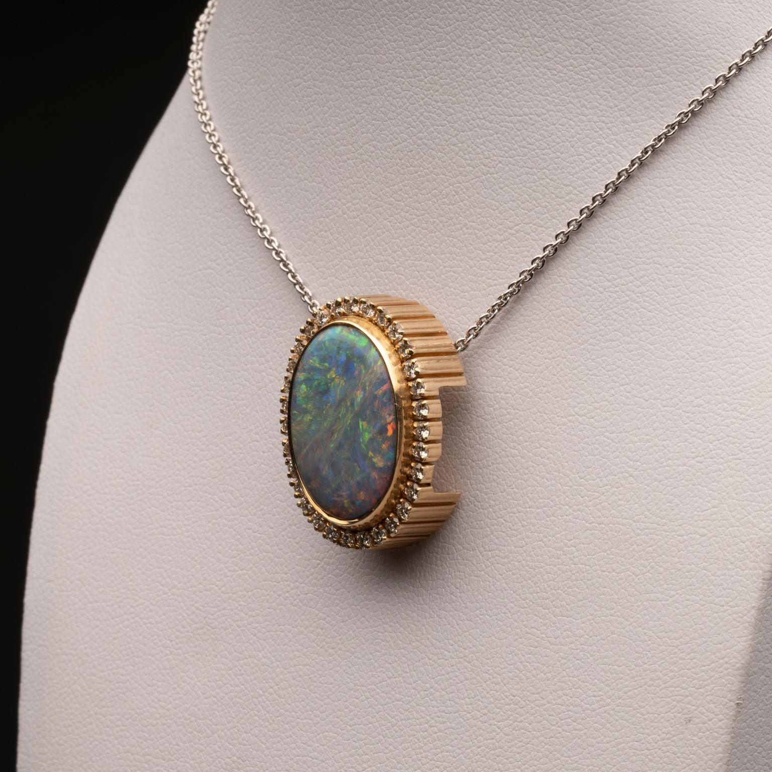 Questo ciondolo appariscente è adatto ai reali. Con un dinamico opale nero australiano incastonato nell'oro giallo 14K e circondato da brillanti bianchi, la catena passa attraverso il centro del pendente per mantenere l'opale come punto focale.