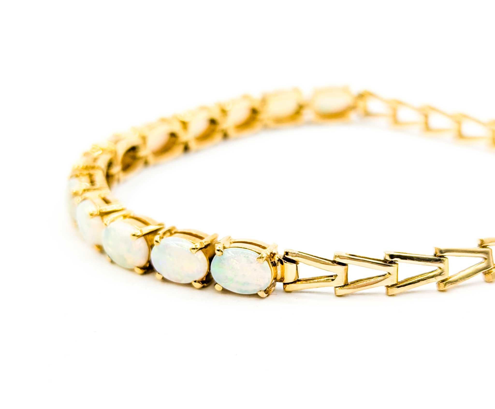 Atemberaubendes australisches Flammenopal-Cabochon-Armband in 18K Gold

Dieses wunderschöne Armband mit australischem Opal ist aus leuchtendem 18 Karat Gelbgold gefertigt. Das Armband besteht aus zwölf 7x5 mm großen australischen Opalen, von denen