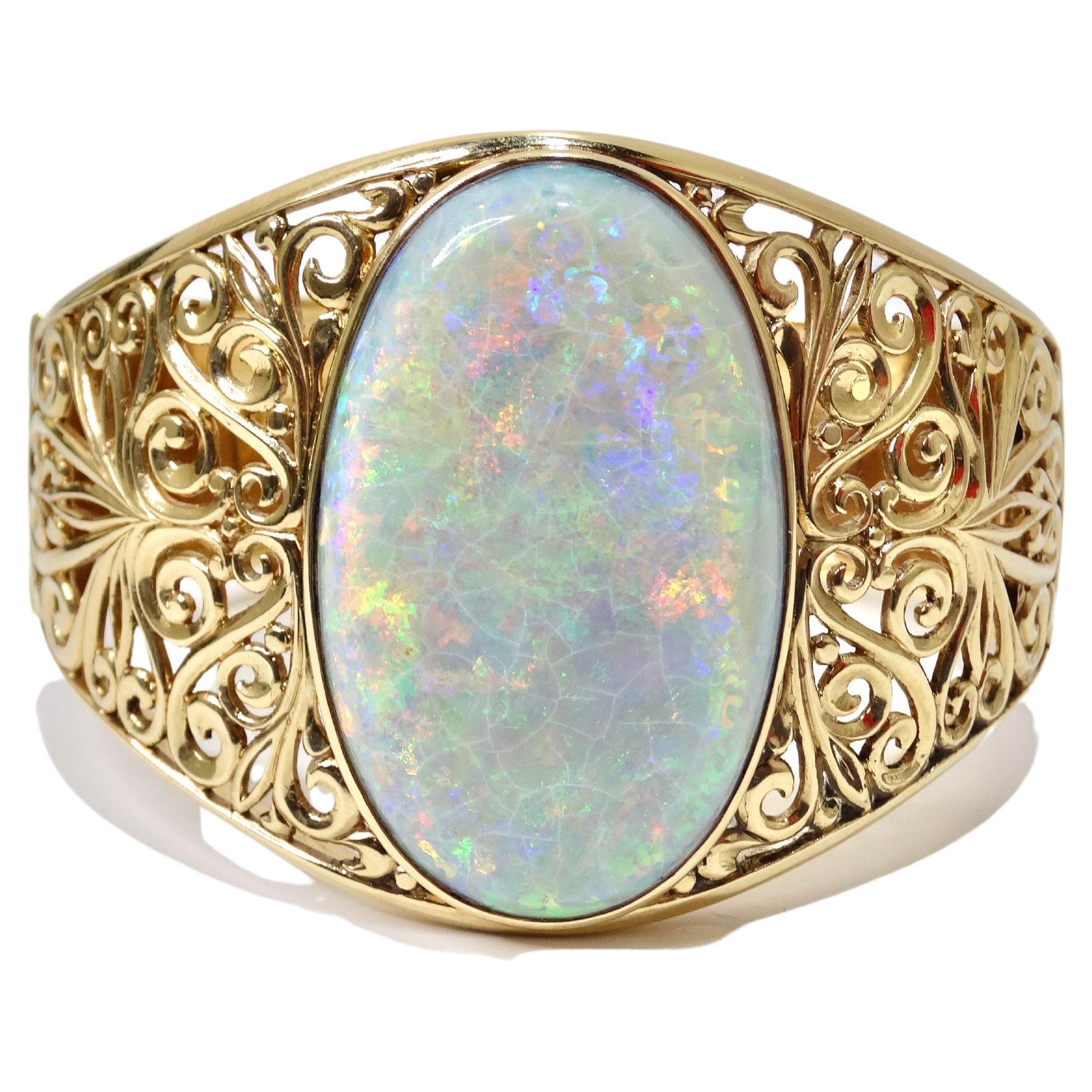 ***Schriftliches Gutachten der International Gemological Appraisal Services

Eine Damenanfertigung, handgefertigt,  14k Gelbgold, ausgezeichnete Qualität, große, natürliche australische Opal Cabochon Armband. Das Armband enthält einen ovalen,