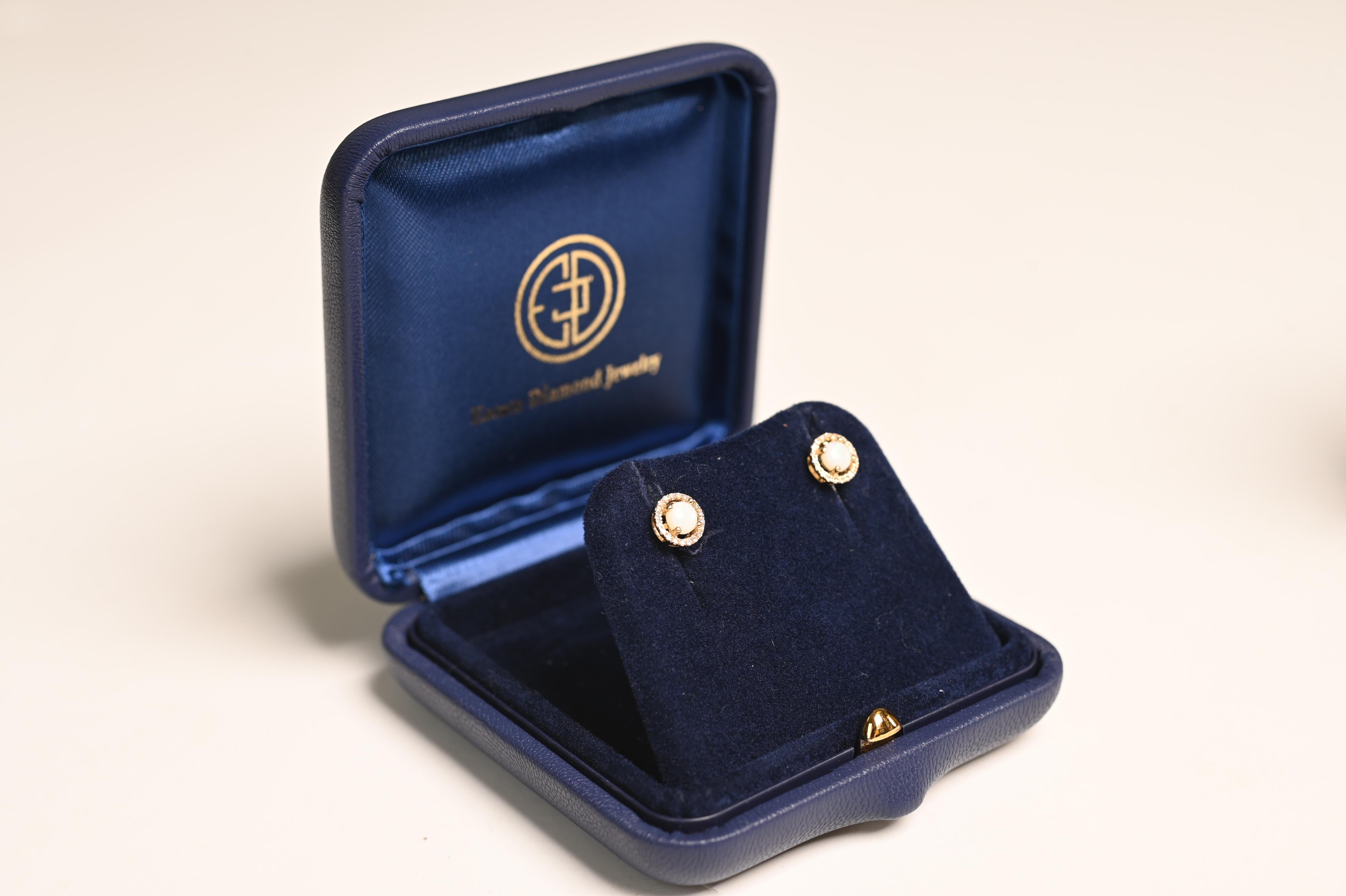 Questo elegante paio di orecchini a perno presenta una raffinata combinazione di opali australiani e diamanti, incastonati ad arte in oro giallo 14k. Al centro di ogni orecchino si trova un opale australiano di circa 0,5 carati a taglio rotondo,