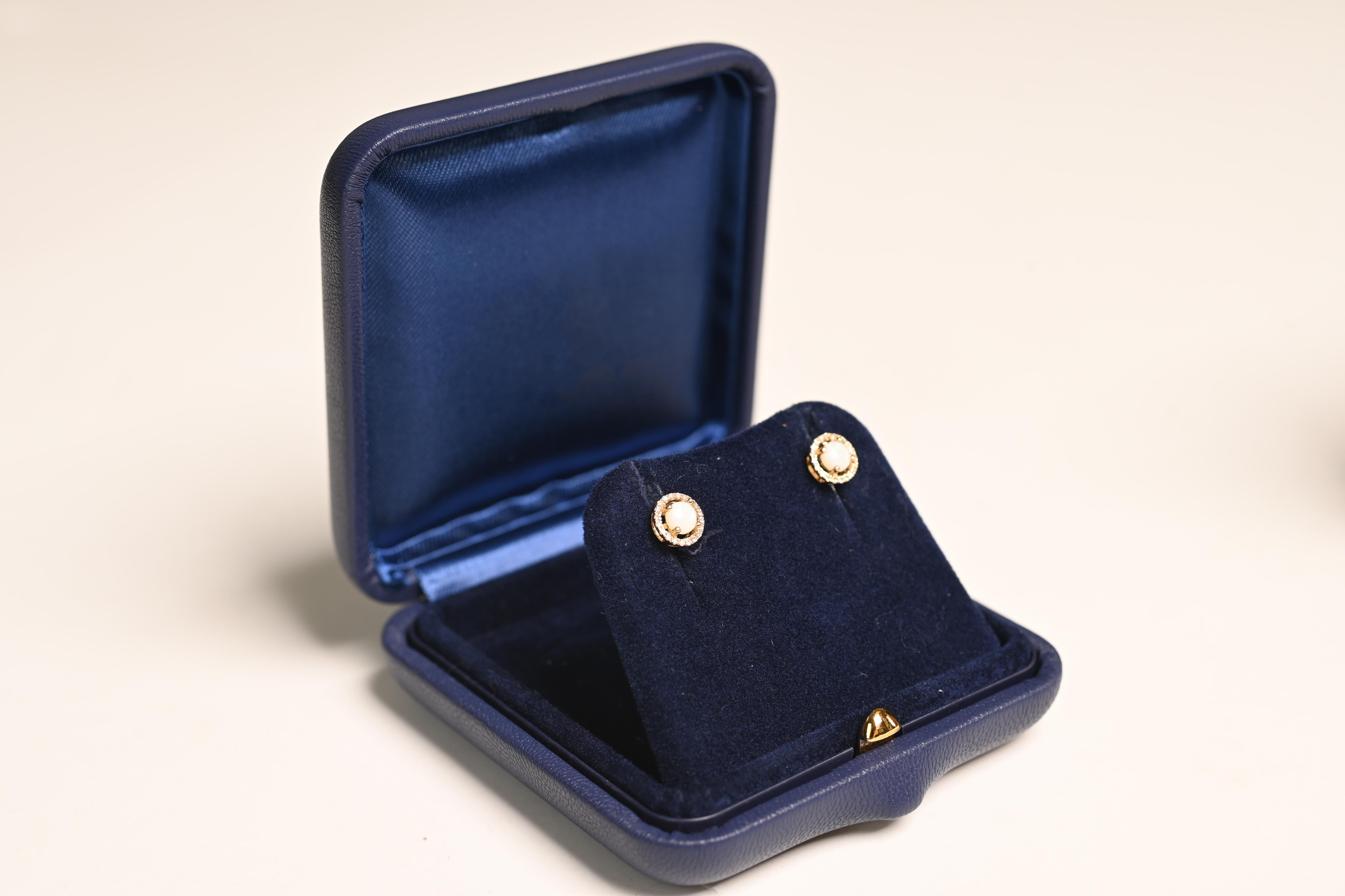 Cette élégante paire d'Eleg met en valeur la beauté éthérée des opales australiennes, d'un poids total d'environ 0,5 carat, solidement enchâssées dans de délicates montures à griffes. Chaque opale est entourée d'un halo scintillant de diamants