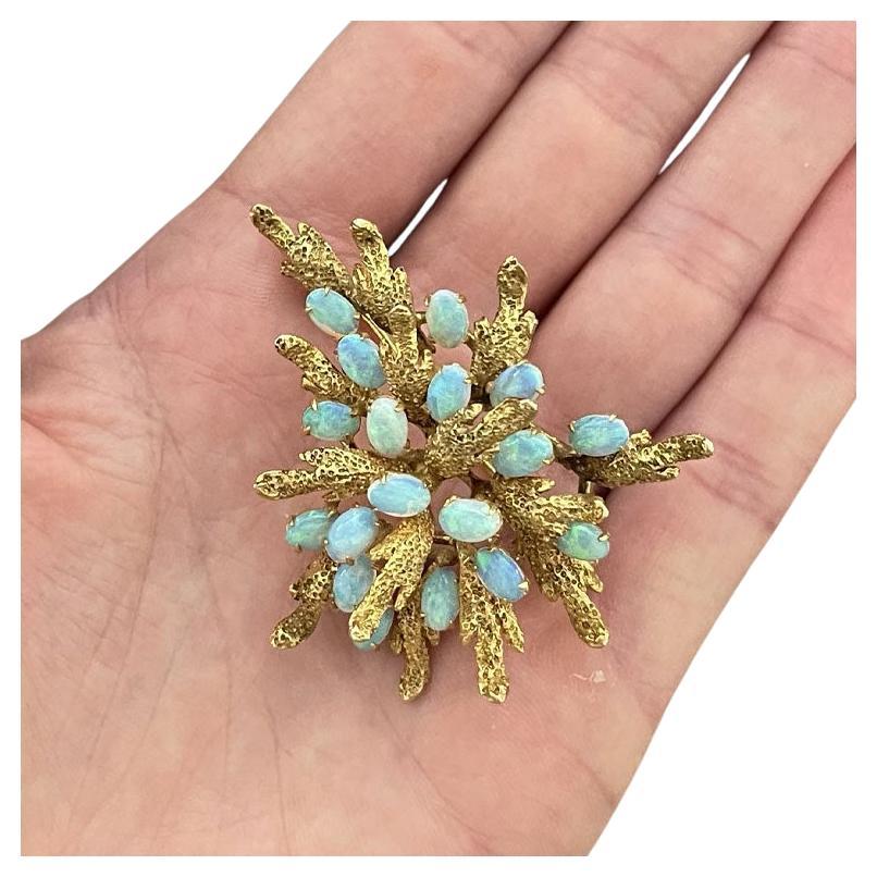 Stunning Australian opal brooch in 14k yellow gold. This beautiful brooch features 18 oval cabochon with magnificent colors. The opals feature vivid blue, green, and orange hues with beautiful color play. The opals total weight is ~4.00 carats. The