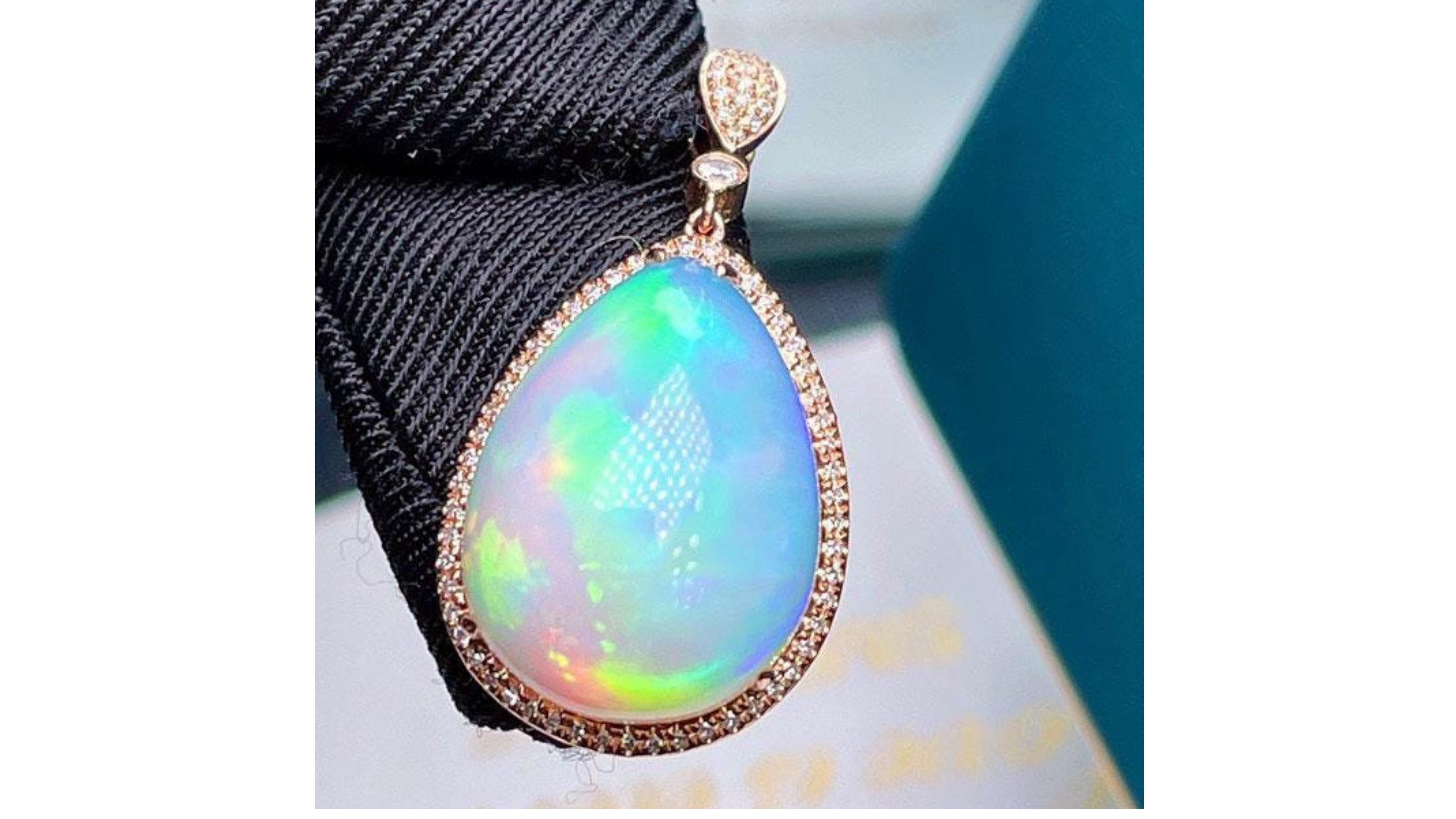 

This Ethiopian Opal shows off Very Bright Colors Blue Yellow Green  Pink Orange and stands out also with  76 diamonds including ones on the bail 

Ethiopian Opal is a new variety of opal discovered in Wollo province of Ethiopia. It is highly