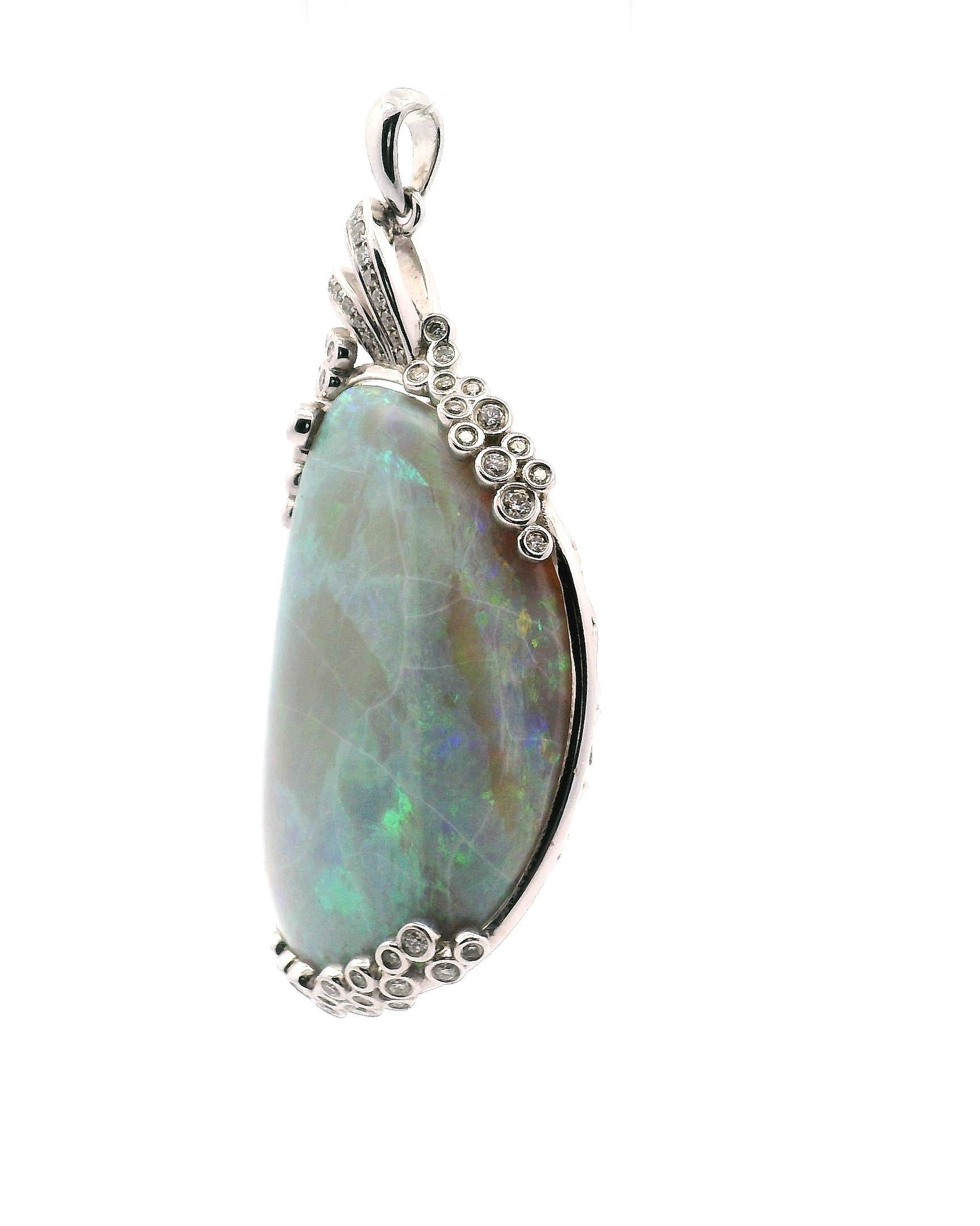 Australian semi-black opal with play of color mostly green 37 X 22 X10mm in size. 
Adorned with 38 round diamonds. Consisting of 

1 Opal approximately 37.60 ct. 

38 round brilliant cut diamonds approximately .40 cttw.
Clarity grade VS1
Color grade