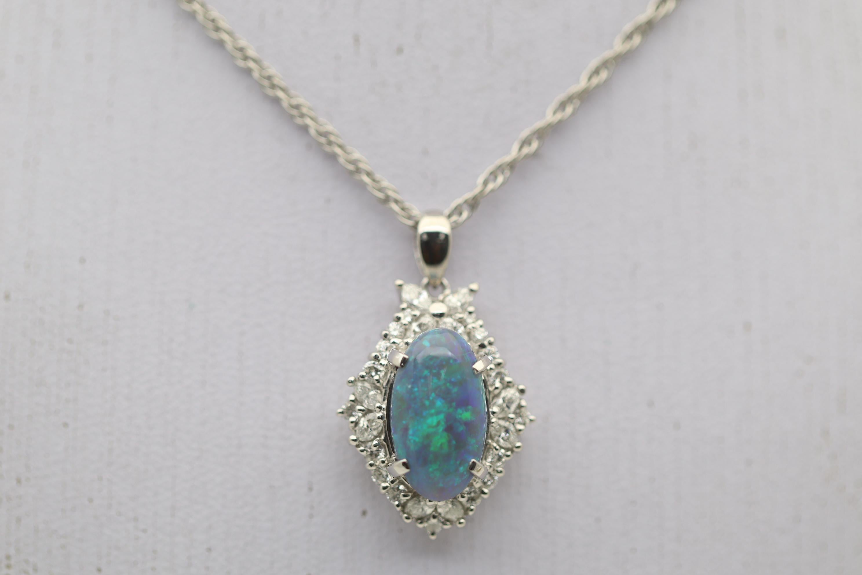 A lovely platinum pendant featuring a natural Australian opal! It weighs approximately 4 carats and has great play-of-color as flashes of greens and blues can be seen across the stone. It is complemented by 0.78 carats of marquise and round