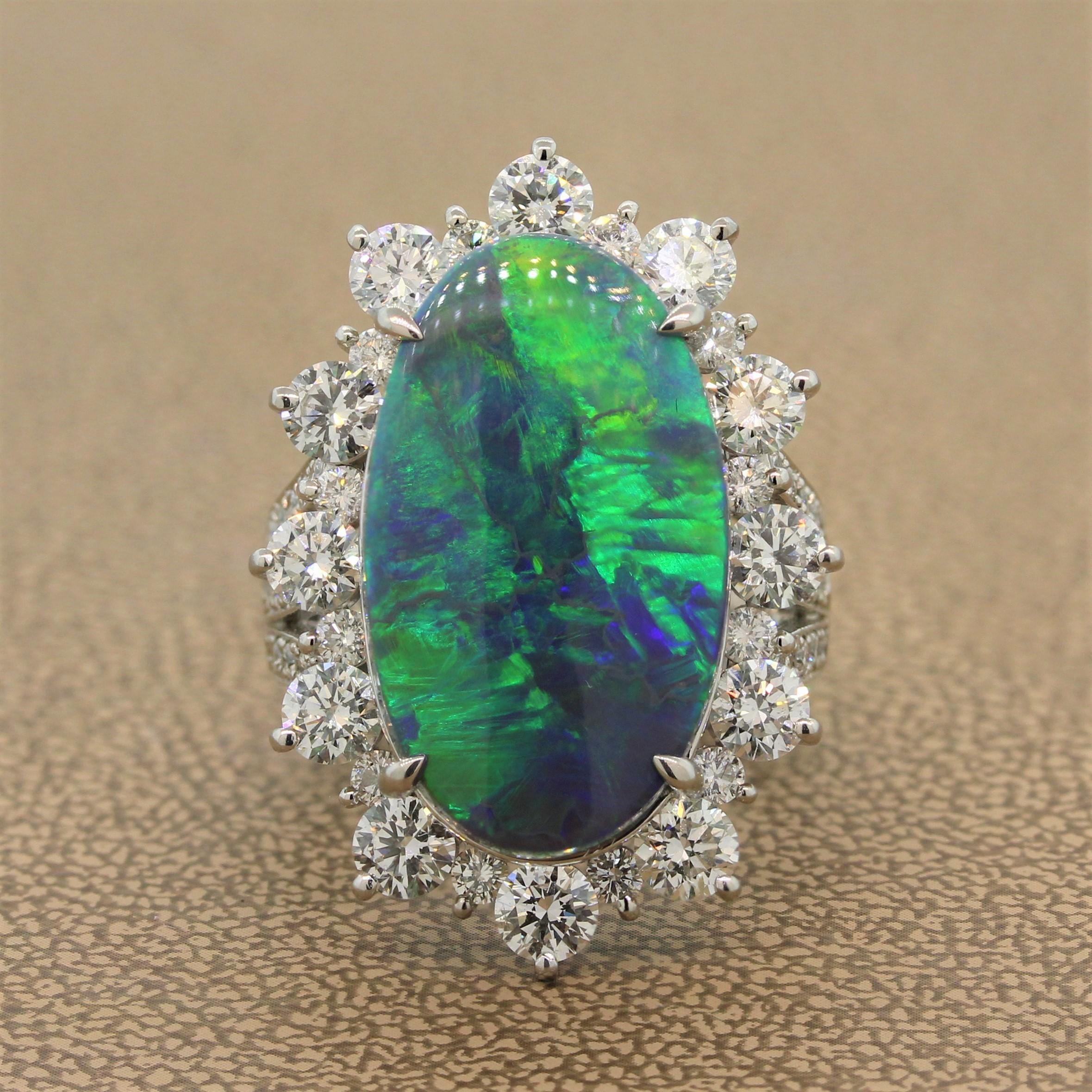 A magnificent 11.74 carat Australian opal in a platinum setting with a double split shank. The elongated opal shows amazing play of color with bright and string flashes of green and blue. It is haloed by 3.15 carats of large round brilliant cut