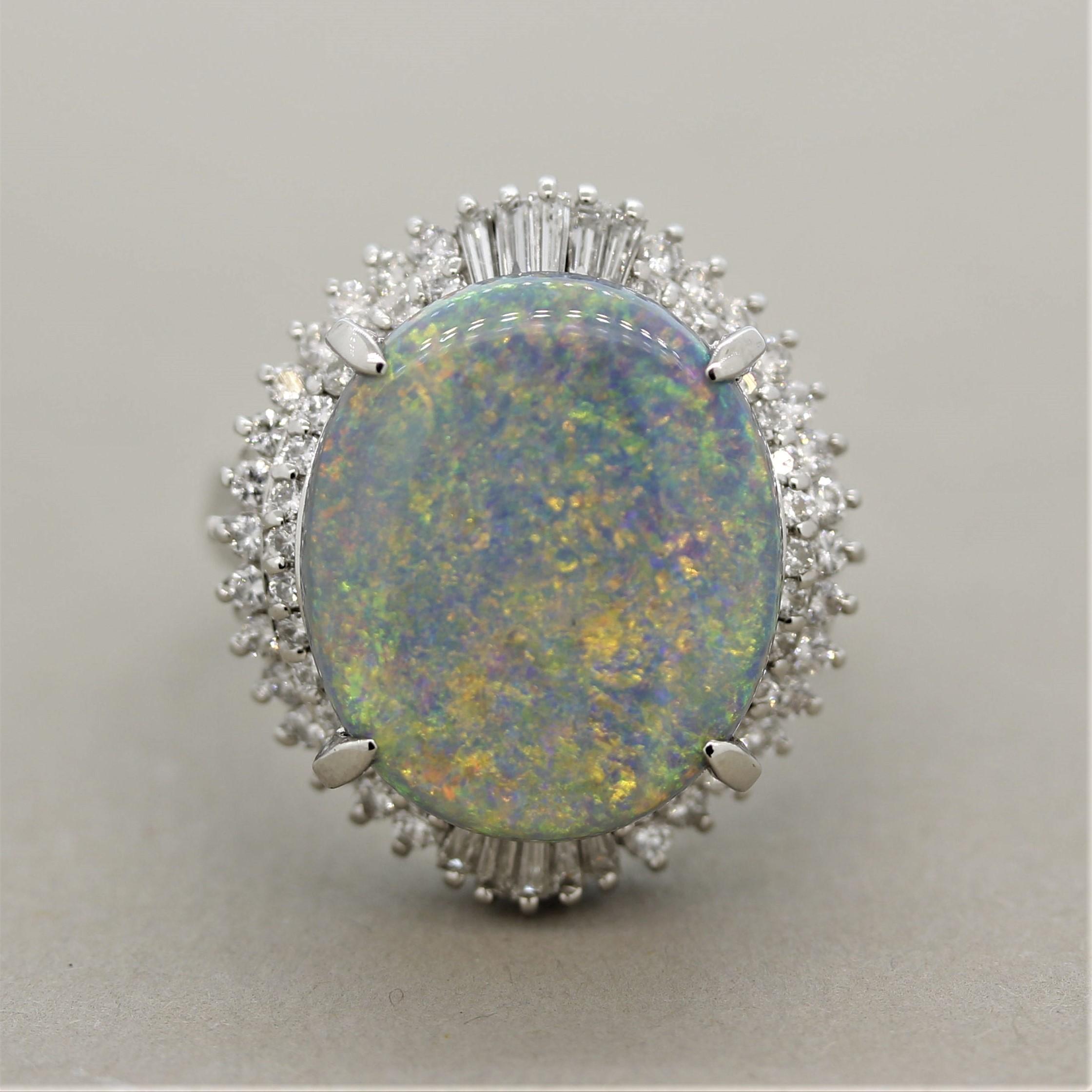 A large and impressive Australian opal weighing 5.97 carats! It has excellent play of color with a classic pin-fire pattern as it shows flashes of greens, reds, yellows and more! It is surrounded by 0.83 carats of round brilliant and baguette cut