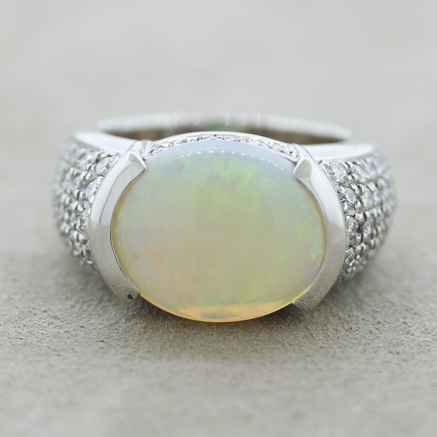 A lovely Australian opal which falls between a white and crystal opal, most likely from Lightning Ridge. It weighs 4.54 carats and has great play of color as the pattern rolls softly across the stone. It is accented by 0.91 carats of round