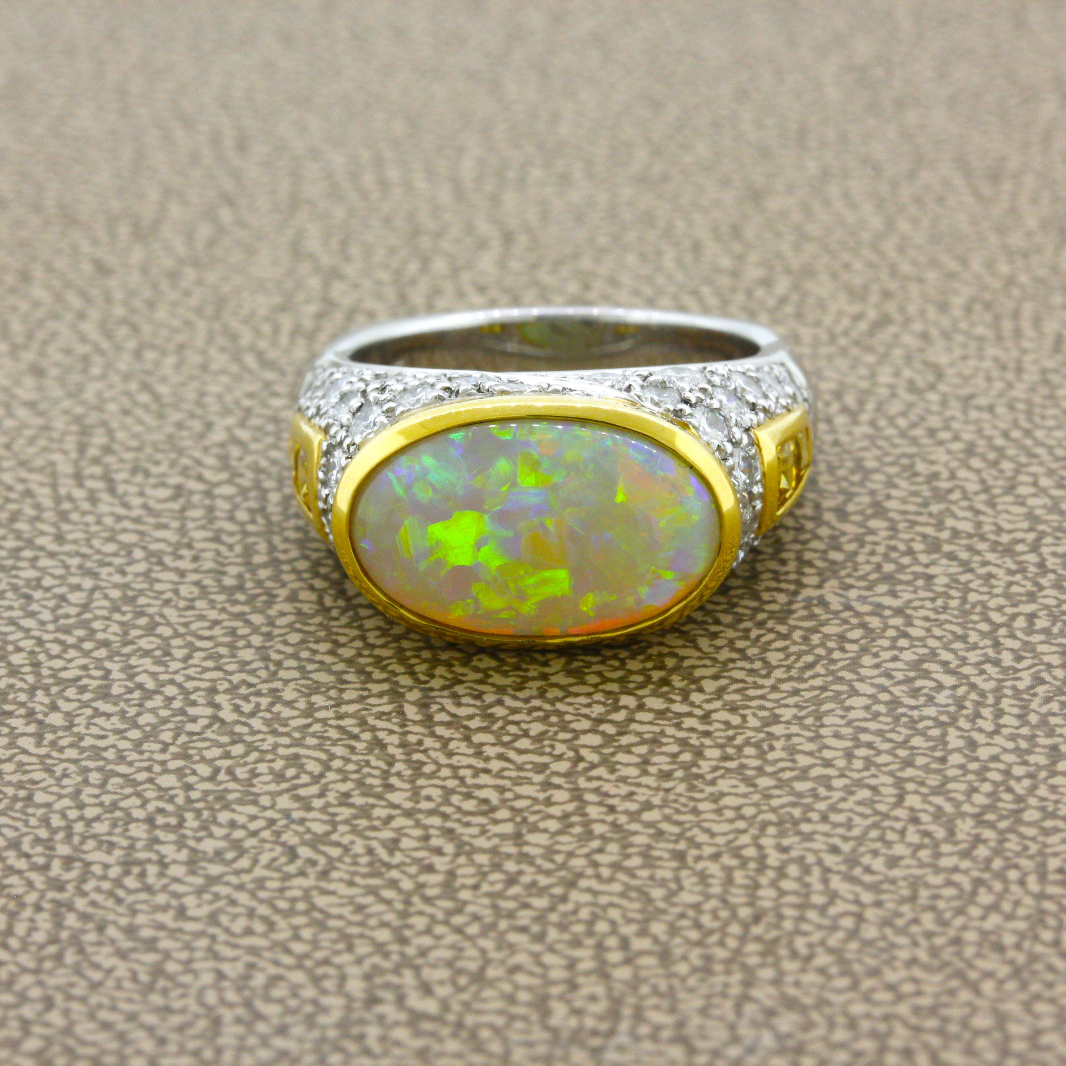 A superb Australian opal weighing 4.45 carat takes center stage of this lovely two-tone platinum gold ring. The opal has excellent play-of-color as gorgeous flashes of green, blue, orange, violet, and yellow dance across the stone. It is