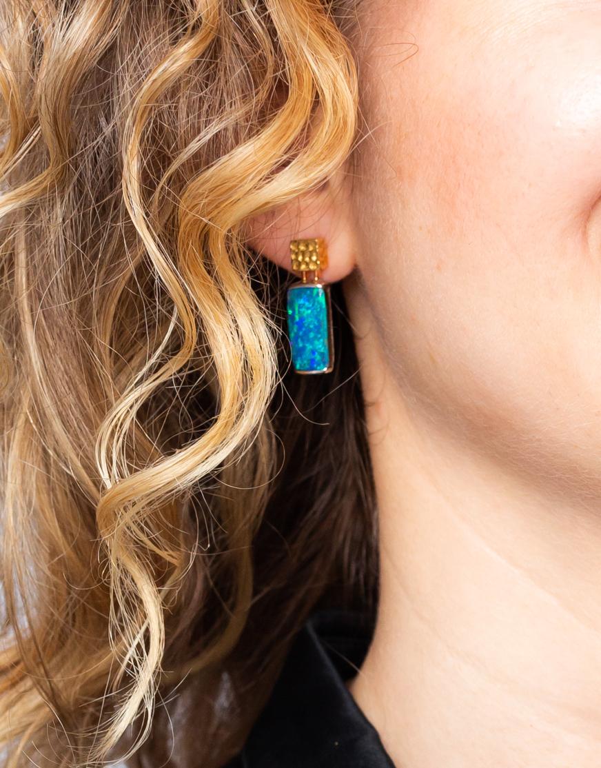 Striking and utterly beguiling, “Amor Eterno” opal earrings are impossible to miss. Natural boulder opals (12.56ct) show off their vivid green and blue colour-play against a texture of hammered yellow and white gold, referencing the modernist