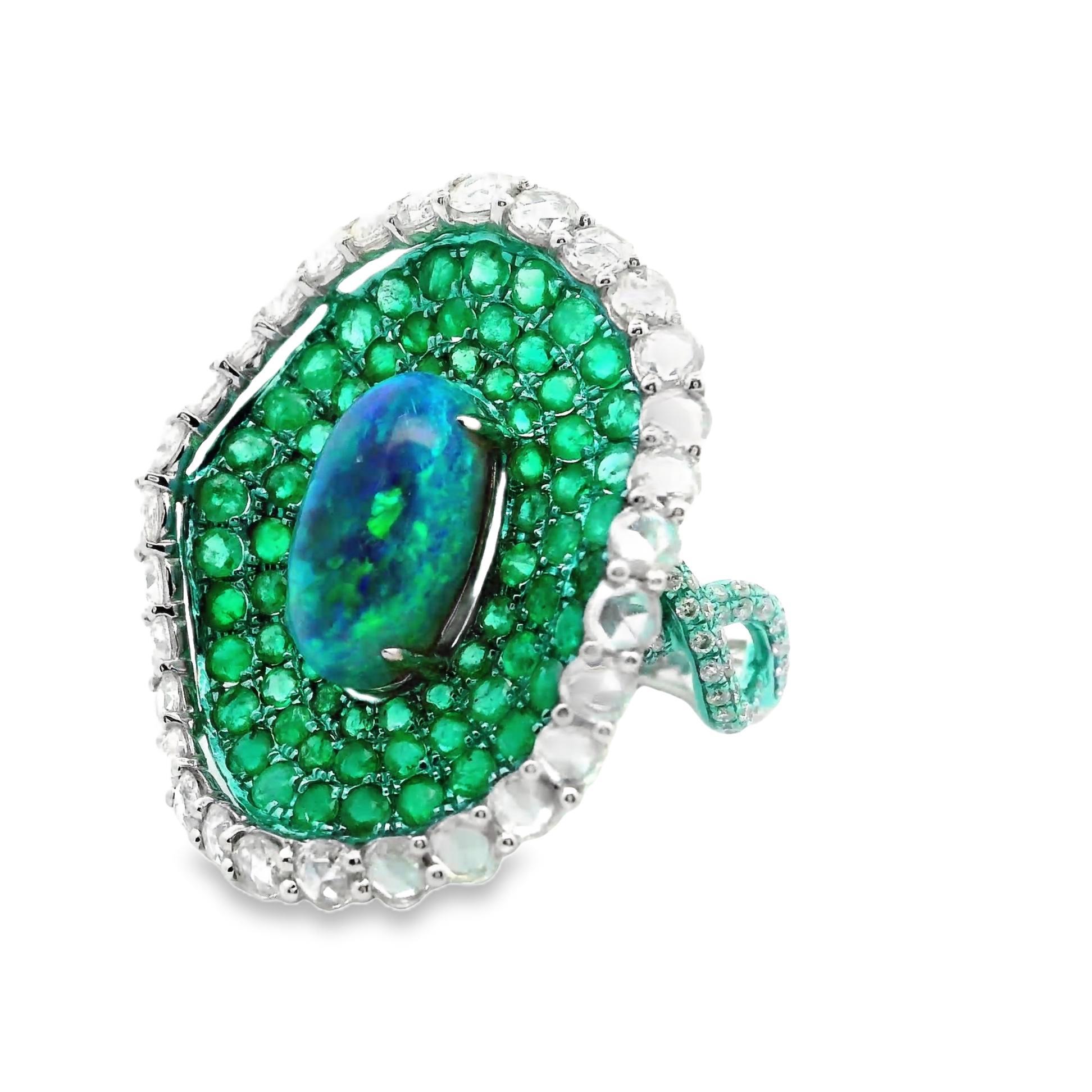Un anillo de cóctel único con un diseño moderno y exclusivo. Presenta un ópalo australiano de 3,42 quilates con un excelente juego de colores con fuertes destellos de azul y verde junto con destellos de rojo y amarillo. Está rodeada por 2,64
