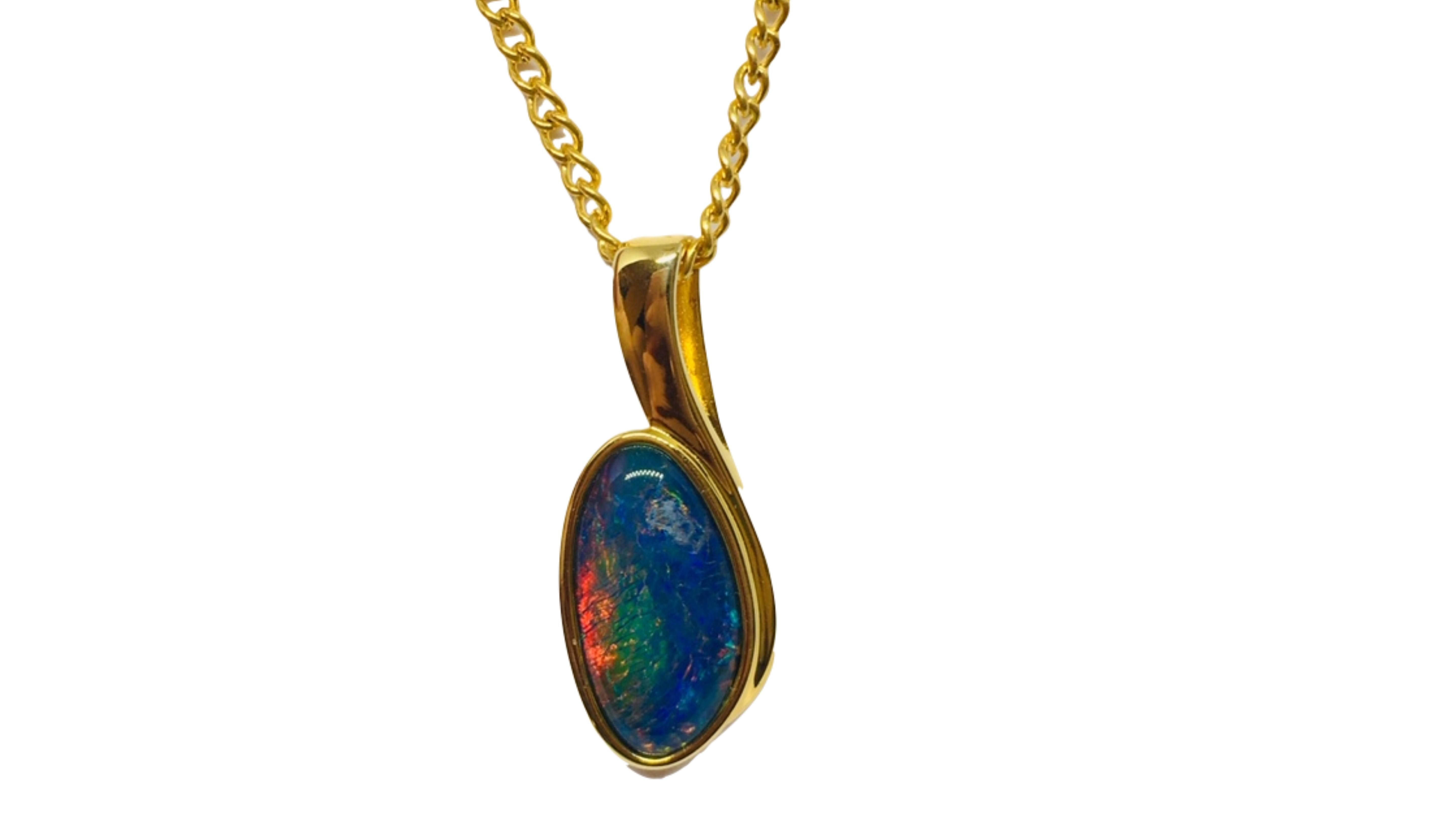 Australian Opal Necklace Sterling Silver . This shows off bright colors Green Blue Yellow Orange Red set in Sterling Silver with accent stones on the top. Red is a rare color to see in opals too .  Its  from Coober Pedy South Australia . 

