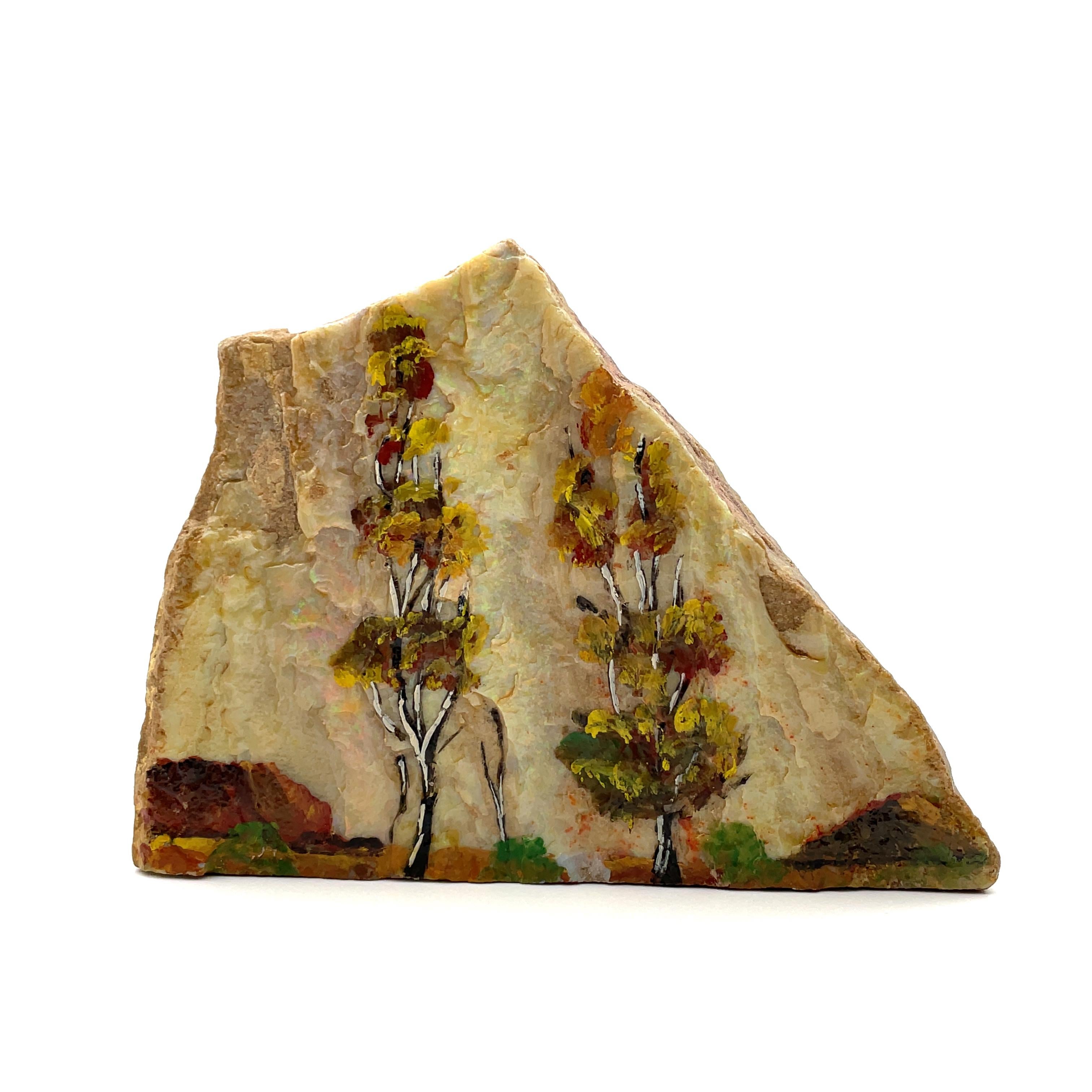 This objet d'art is perfect for someone who loves both gemstones and art! A beautiful nature scene has been hand-painted on this large piece of natural Australian opal rough that displays a rainbow of colors in different light sources. Reds,