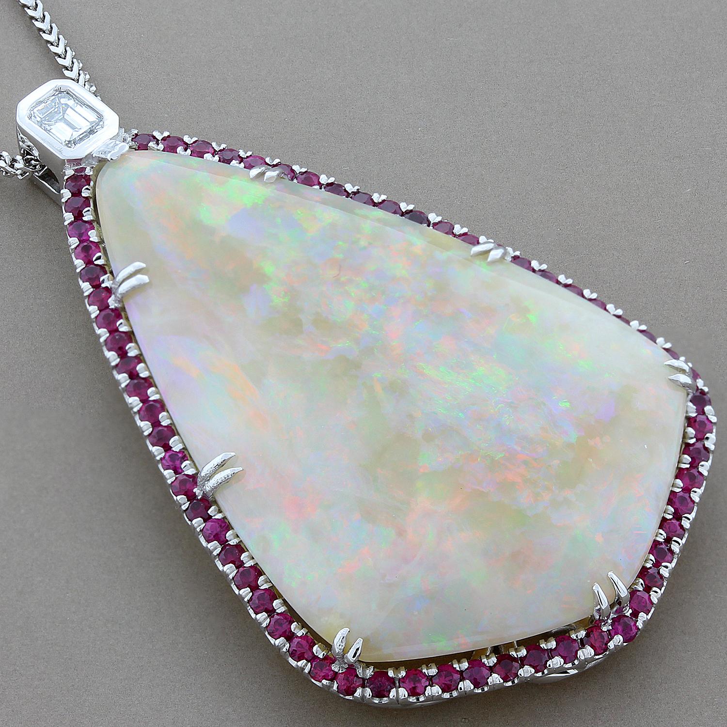 A special 34.84 carat kite shape double cabochon natural opal is bordered by 2.18 crats of round rubies. Revered as a symbol of hope, fidelity and purity, opal was dubbed the Queen of Gems by the ancient Romans because it encompasses the colors of