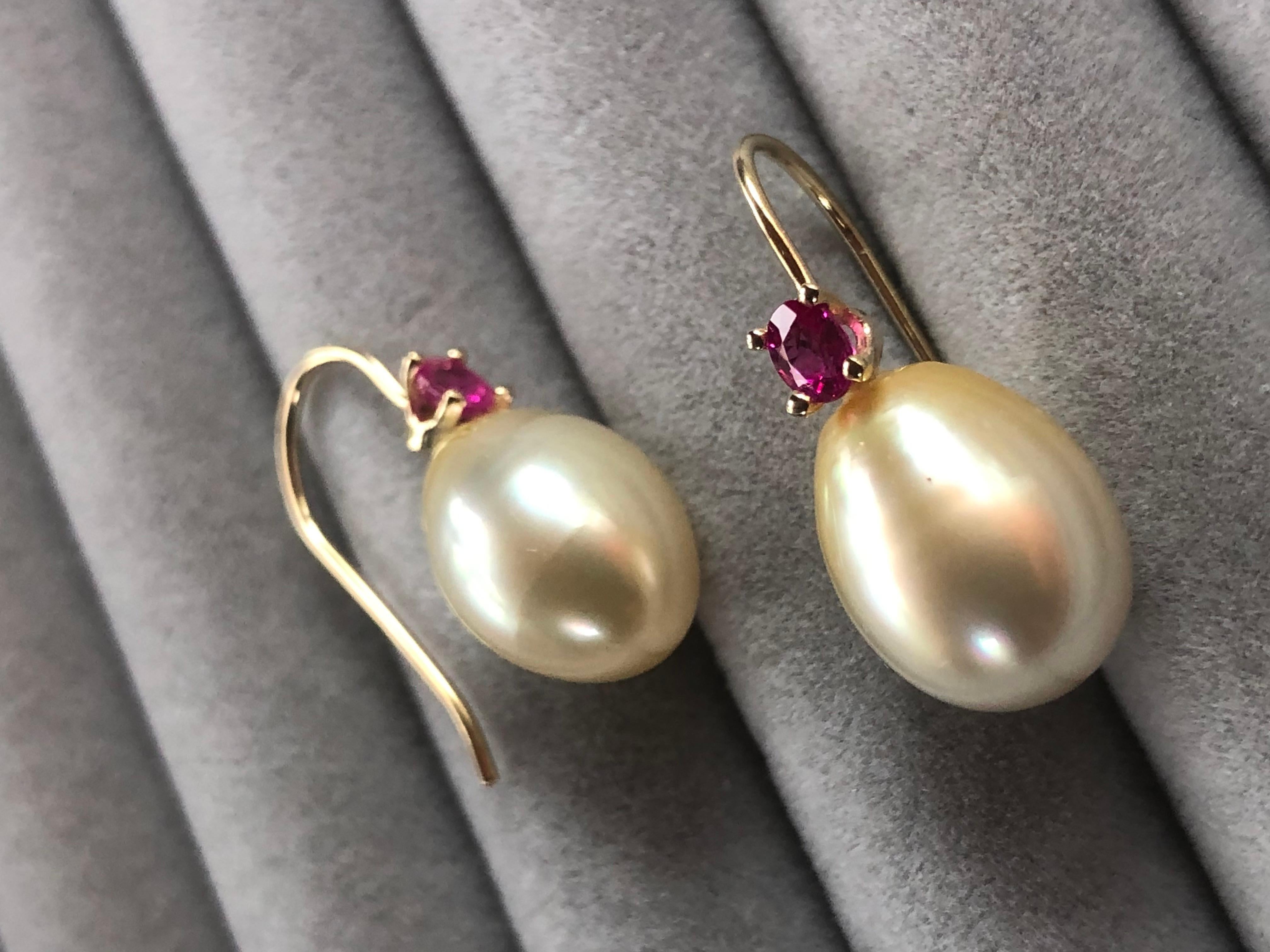 Ein Paar australischer Perlen ist in ein wunderschönes Design aus 14-karätigem Gelbgold eingefasst, das mit einem 0,70-karätigen natürlichen Rubin besetzt ist. Diese wunderschönen Ohrringe lassen die Trägerin bei jeder Gelegenheit strahlen.