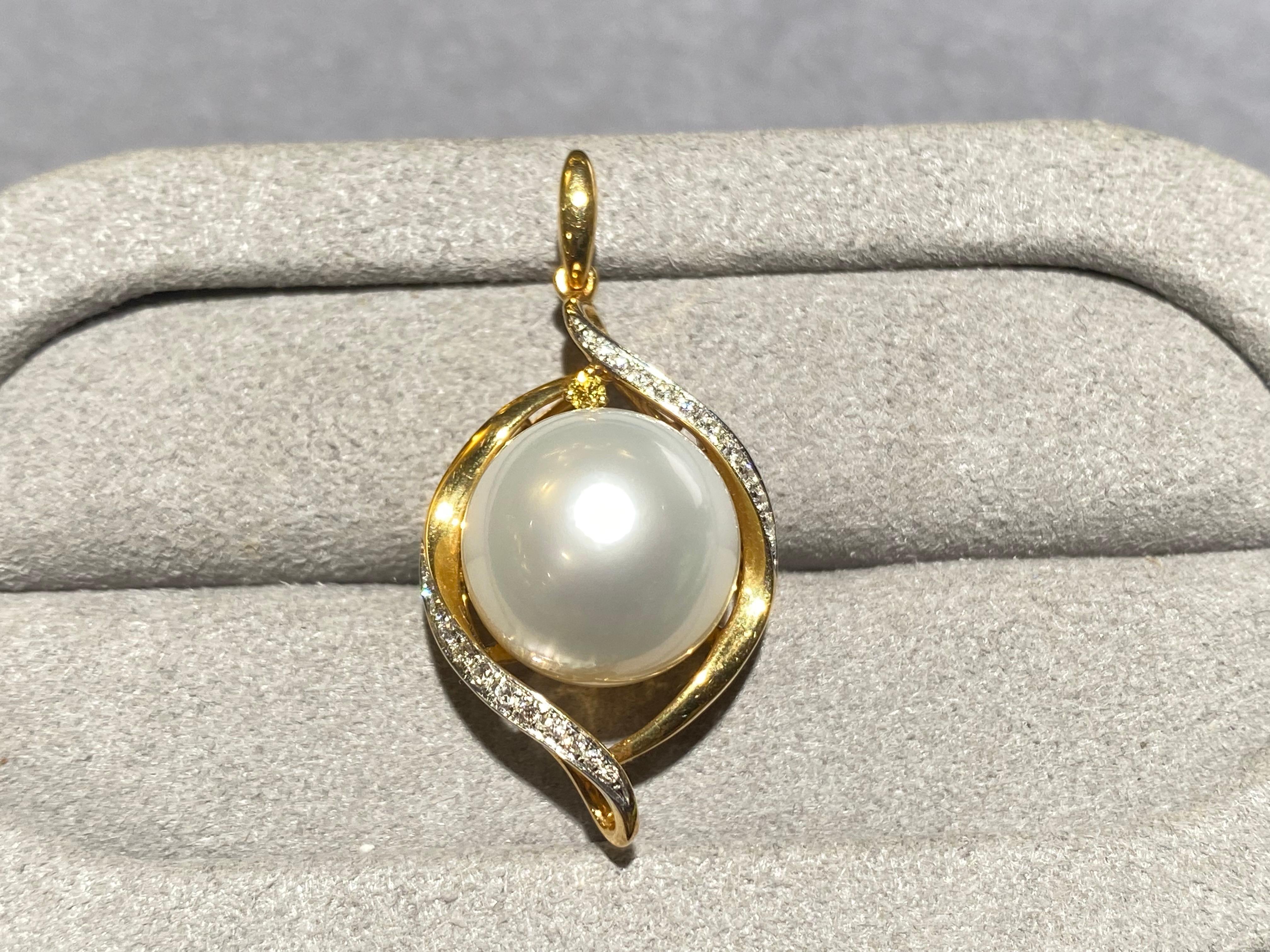 A 12 mm White Australian South Sea Pearl and Diamond pendant in 18k yellow gold. It is a design that resemble an eye, with the pearl represent the eye ball set between the 18k yellow gold eye lids. The 