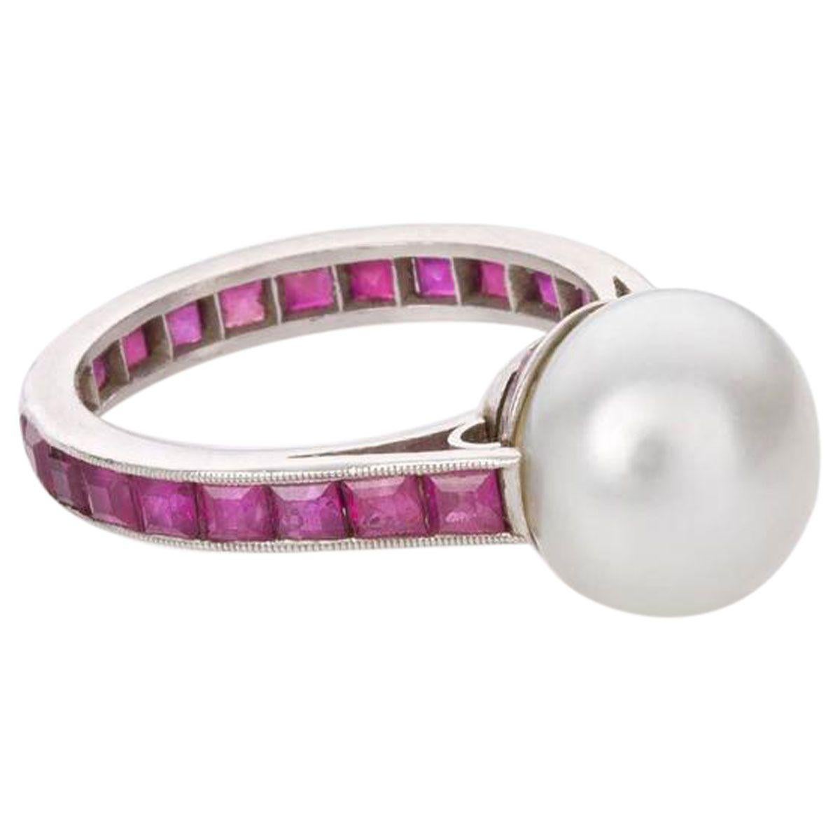 This unique estate Australian South Sea Pearl and Ruby dress ring is such a fabulous piece, so eye-catching and unusual. Featuring at the centre one 10 - 10.5mm button shape South Sea pearl with silver overtones and a bright lustre. The platinum