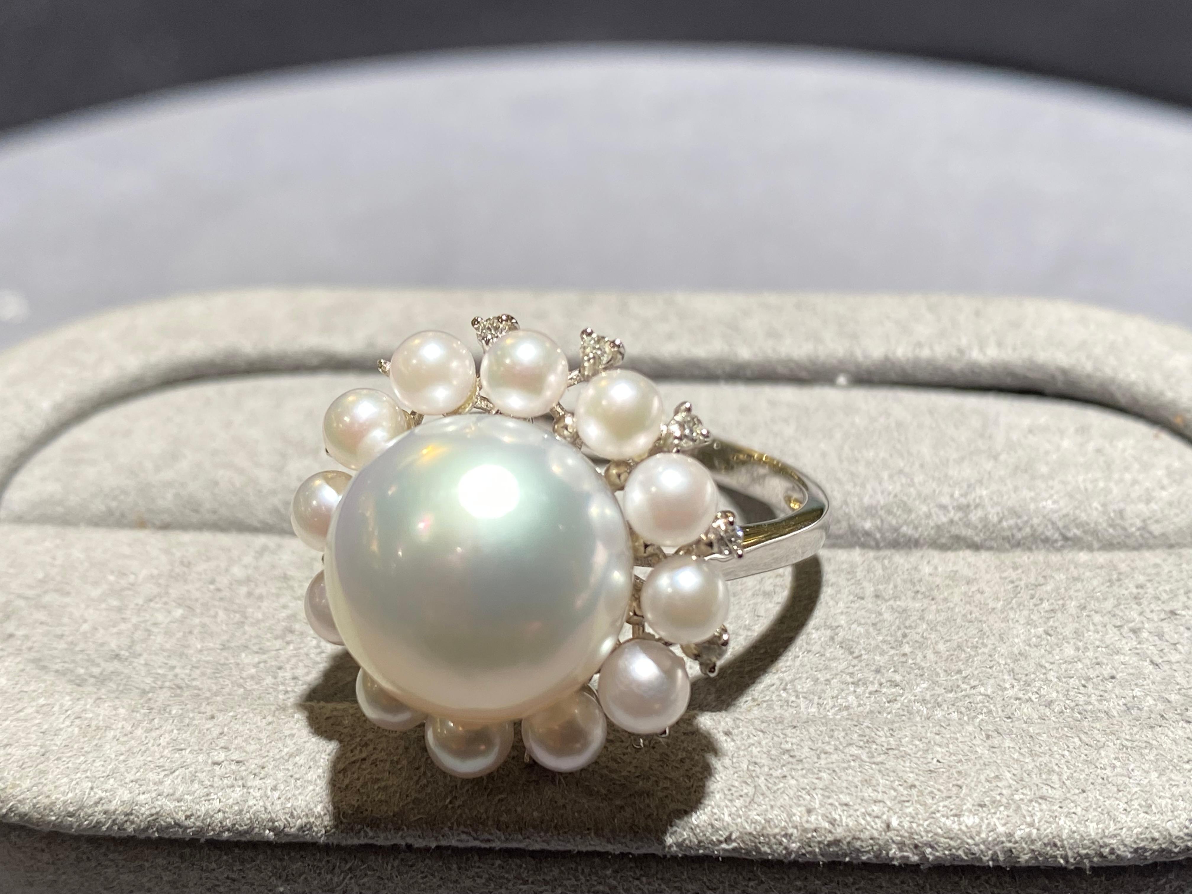 A 12.5 mm white Australian south sea pearl, seed pearl and diamond ring in 18k white gold. The white south sea pearl is surrounded by 12 seed pearls and 12 diamonds. It is a classical cluster design and is perfect for any occasions. The south sea