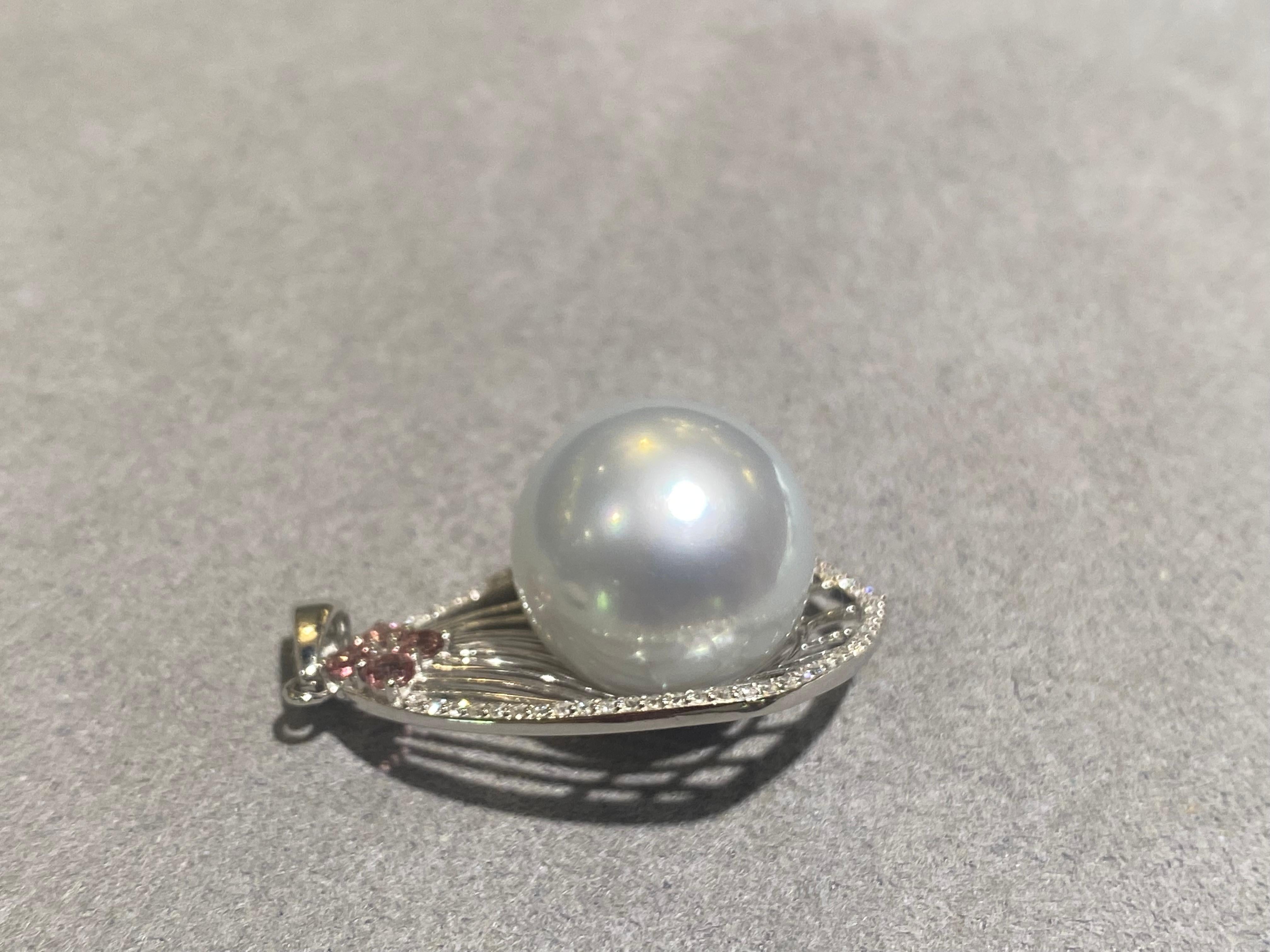 The 14.3mm White Australian South Sea Pearl was set in the middle of a kite like pendant. The peripheral of the pendant was set with diamond pave. The pearl is round in shape. It is white in colour with silver/blue overtone. The pearl has good