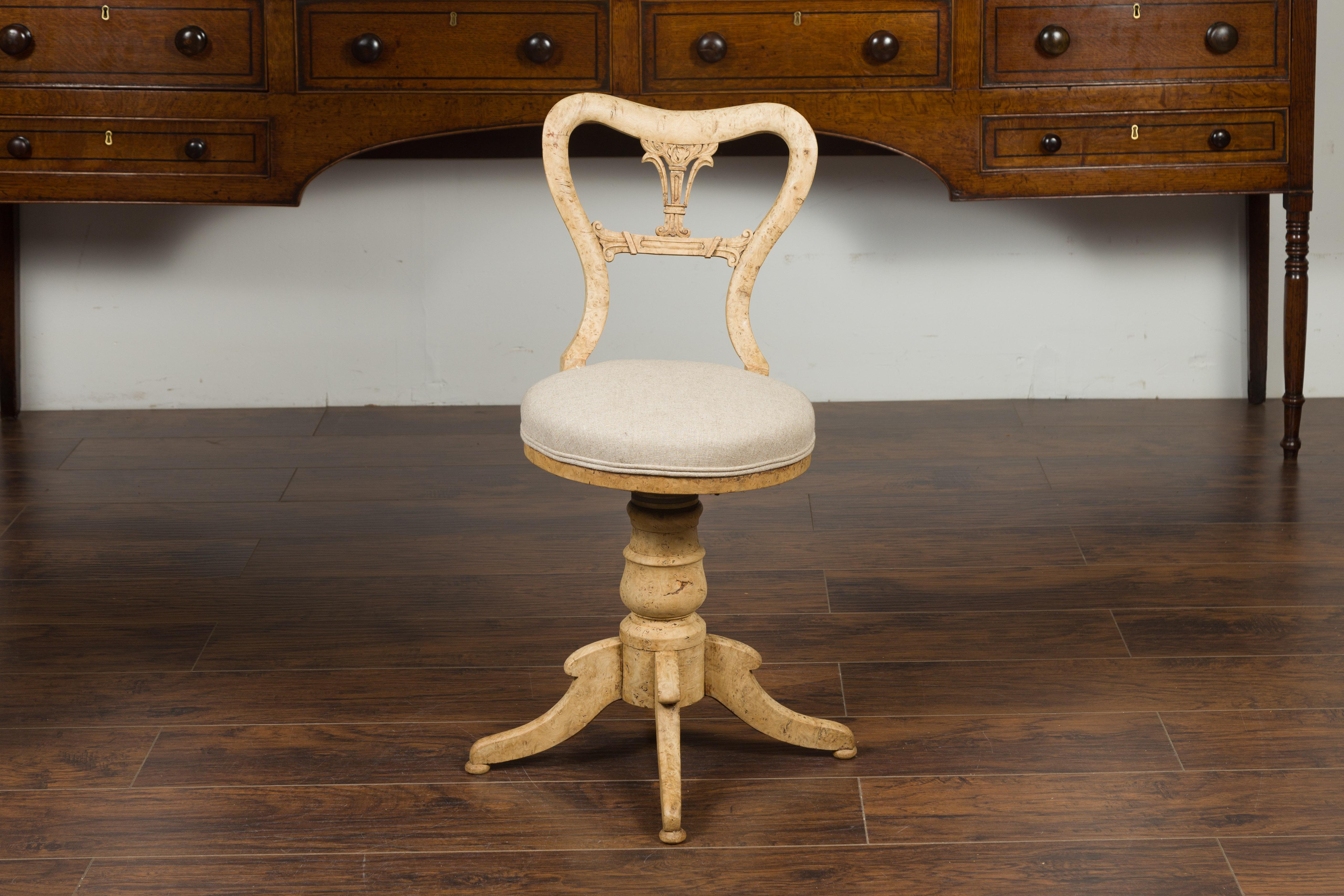 An Austrian Biedermeier bleached burled walnut swivel chair from the mid-19th century, with new upholstery. Born in Austria during the first half of the 19th century, this bleached swivel chair features an exquisite burled walnut pierced back,