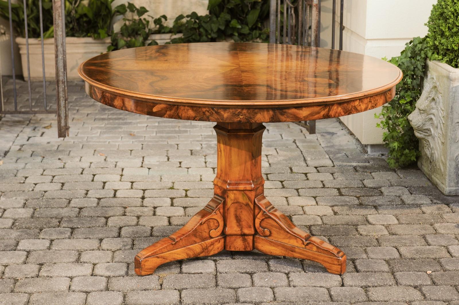 An Austrian Gründerzeit period walnut round top dining table from the late 19th century with radiating veneer and pedestal base. Born in Austria during the second quarter of the 19th century, this dining table features a stunning top adorned with