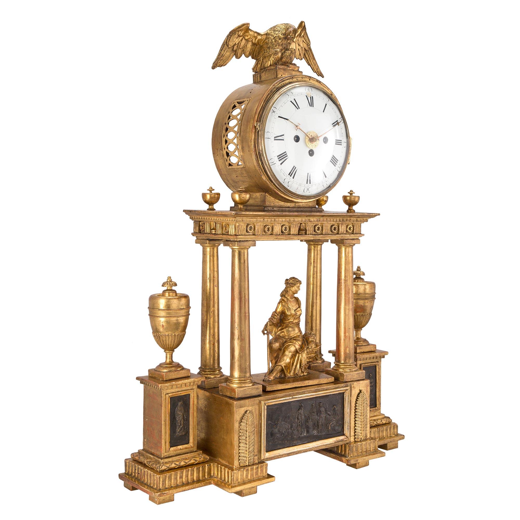 A handsome early 18th century Austrian giltwood and mecca blind mans clock. The clock , with two separate chimes, one for quarter hour and the other for hour. Raised on a solid base with pedestals on each side displaying a mecca plaque supporting an