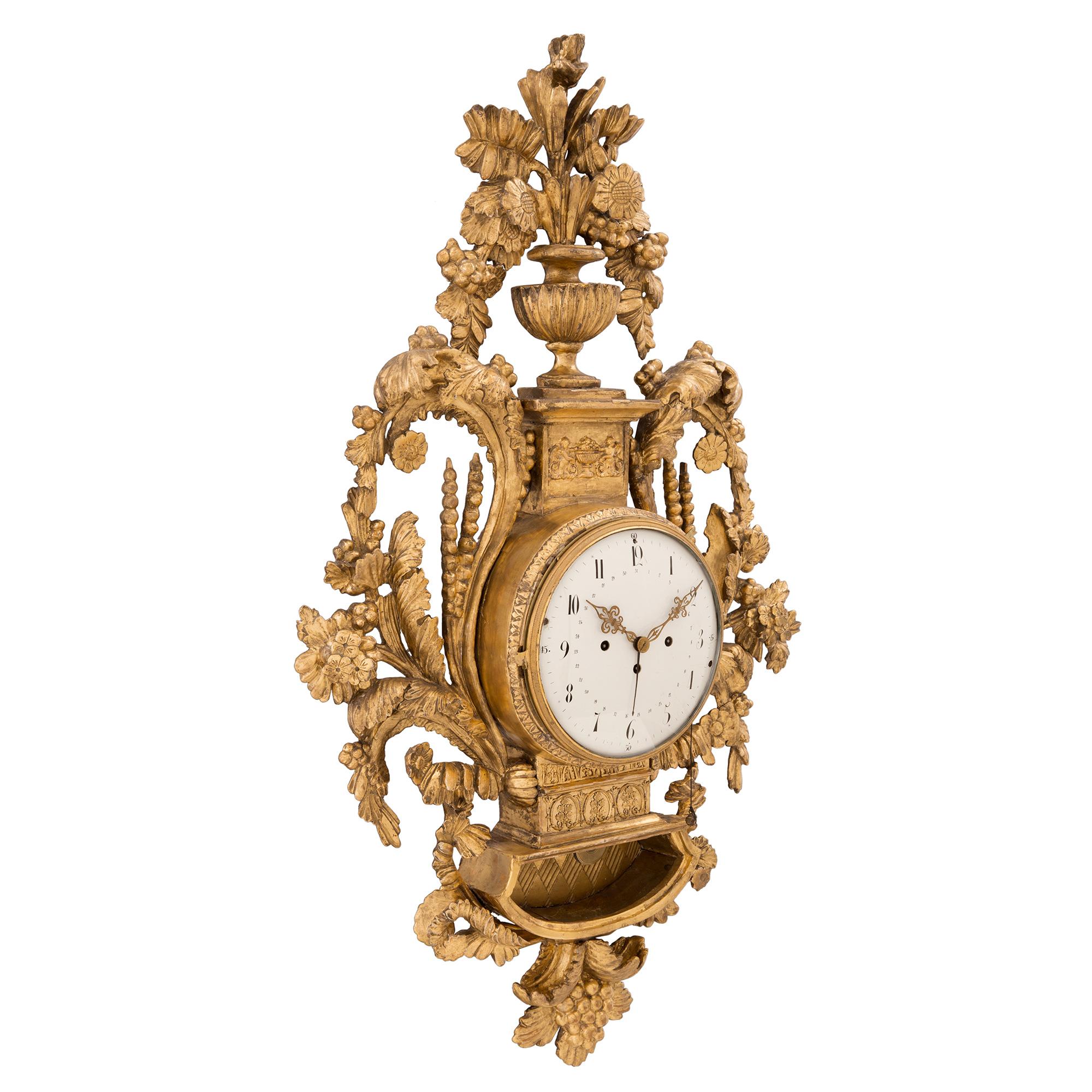 A sensational and extremely high quality Austrian 18th century Louis XVI period giltwood cartel blind man's clock, circa 1740. The clock displays a most exquisitely carved case with intricately detailed scrolled designs, wheat sprigs and stunning