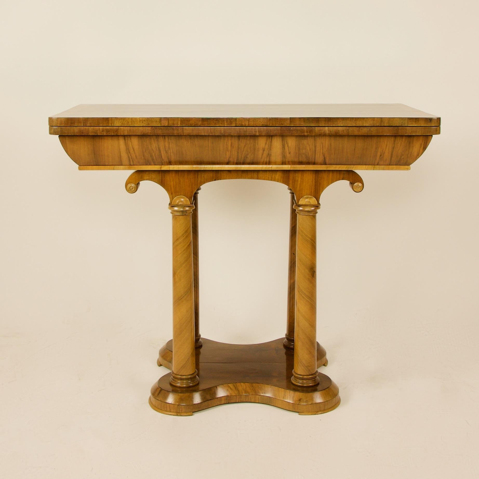 Austrian/Vienna 1st half of 19th century Biedermeier walnut game flip flop top table, ca. 1840:

A Biedermeier extending game table made of walnut veneer with four column shaped tapering legs on a four lobed base. The legs being topped by two arch