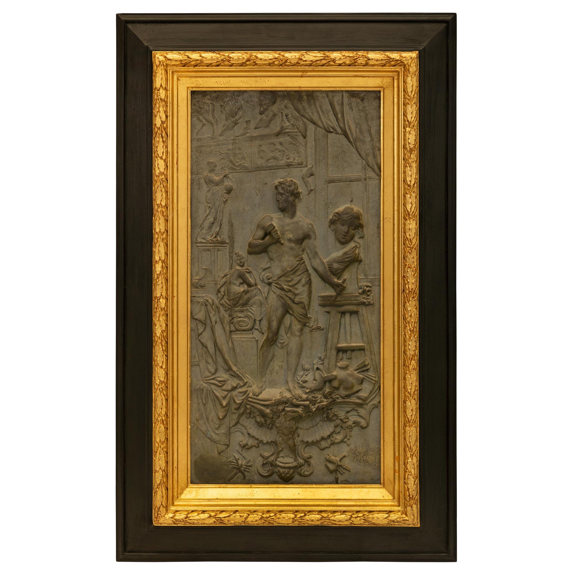 An exceptional and most decorative Austrian 19th century patinated bronze, giltwood and Ebony wall plaque signed K. Sterrer. The striking wall decor is centered by the wonderfully executed patinated bronze plaque depicting a handsome sculptor in his