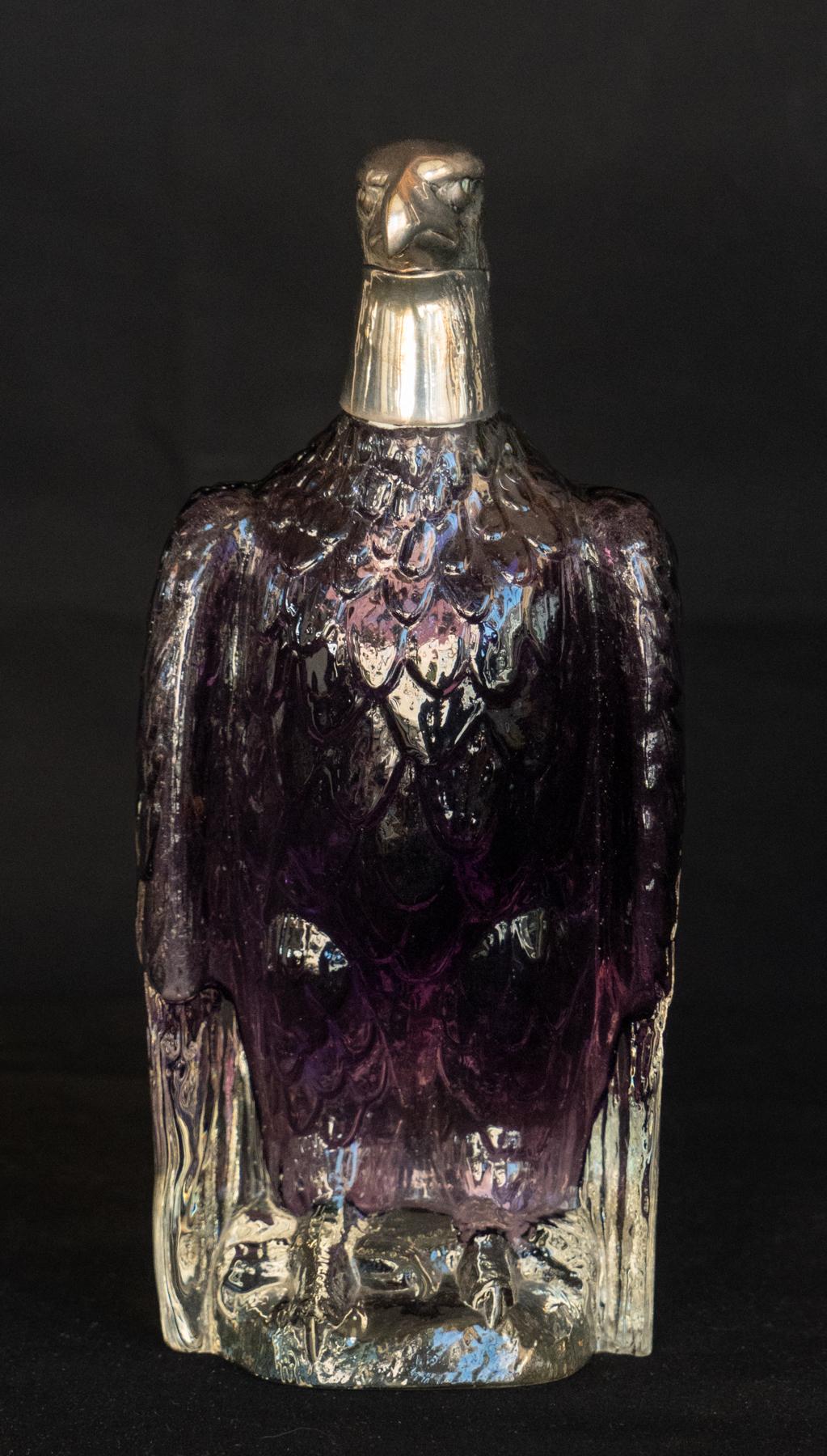 Austrian Amethyst Glass and Silver Decanter in the Form of an Eagle. Heavy cast and shaped glass body with deep amethyst color . The silver plated head stamped Austria on the underside. Good sculpted form and weight. Cork Stopper.




