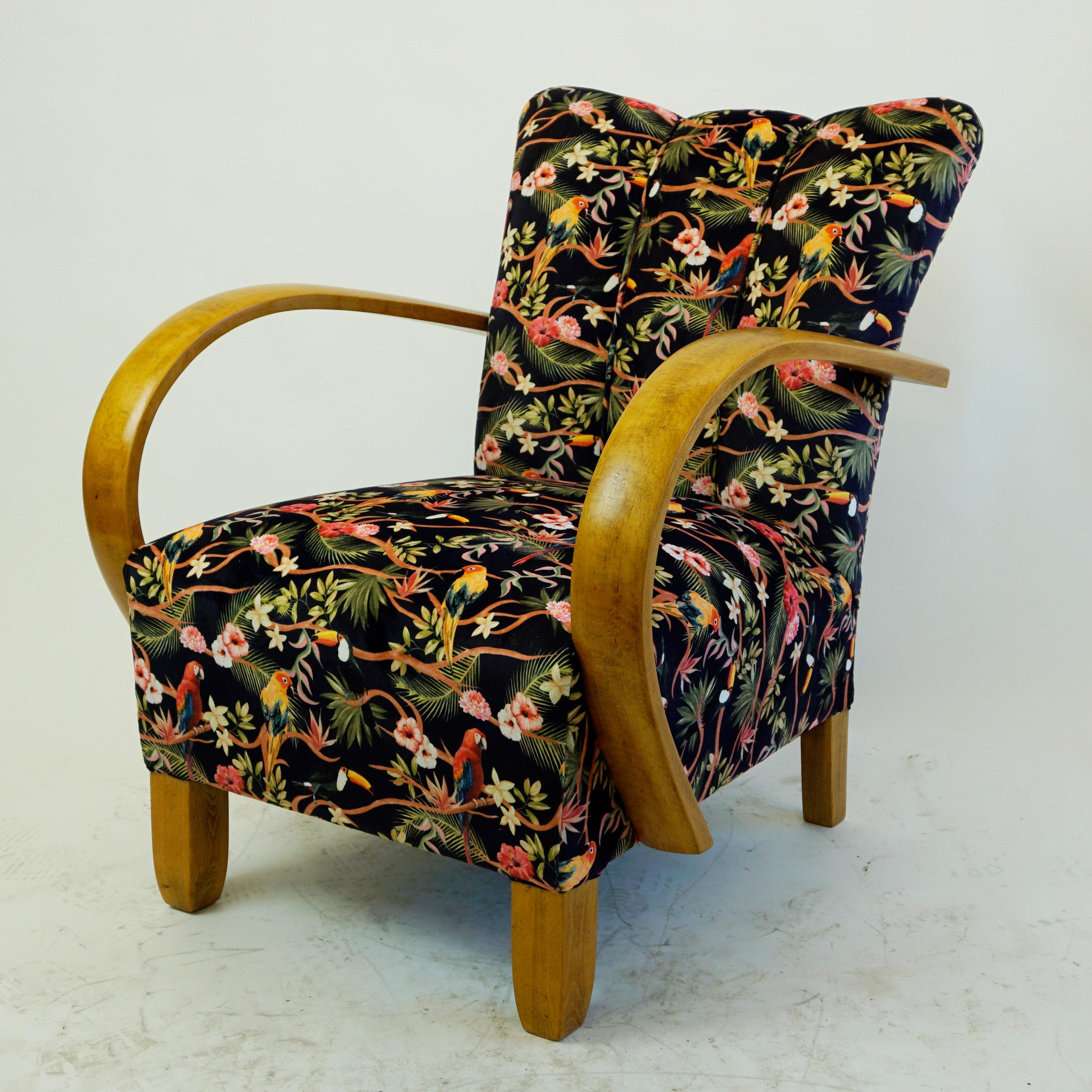 This charming Art Deco armchair has been completely restored and newly upholstered. The structure in beechwood features striking armrests that were curved using steam. The new upholstery is in black velvet with floral motifs and birds.