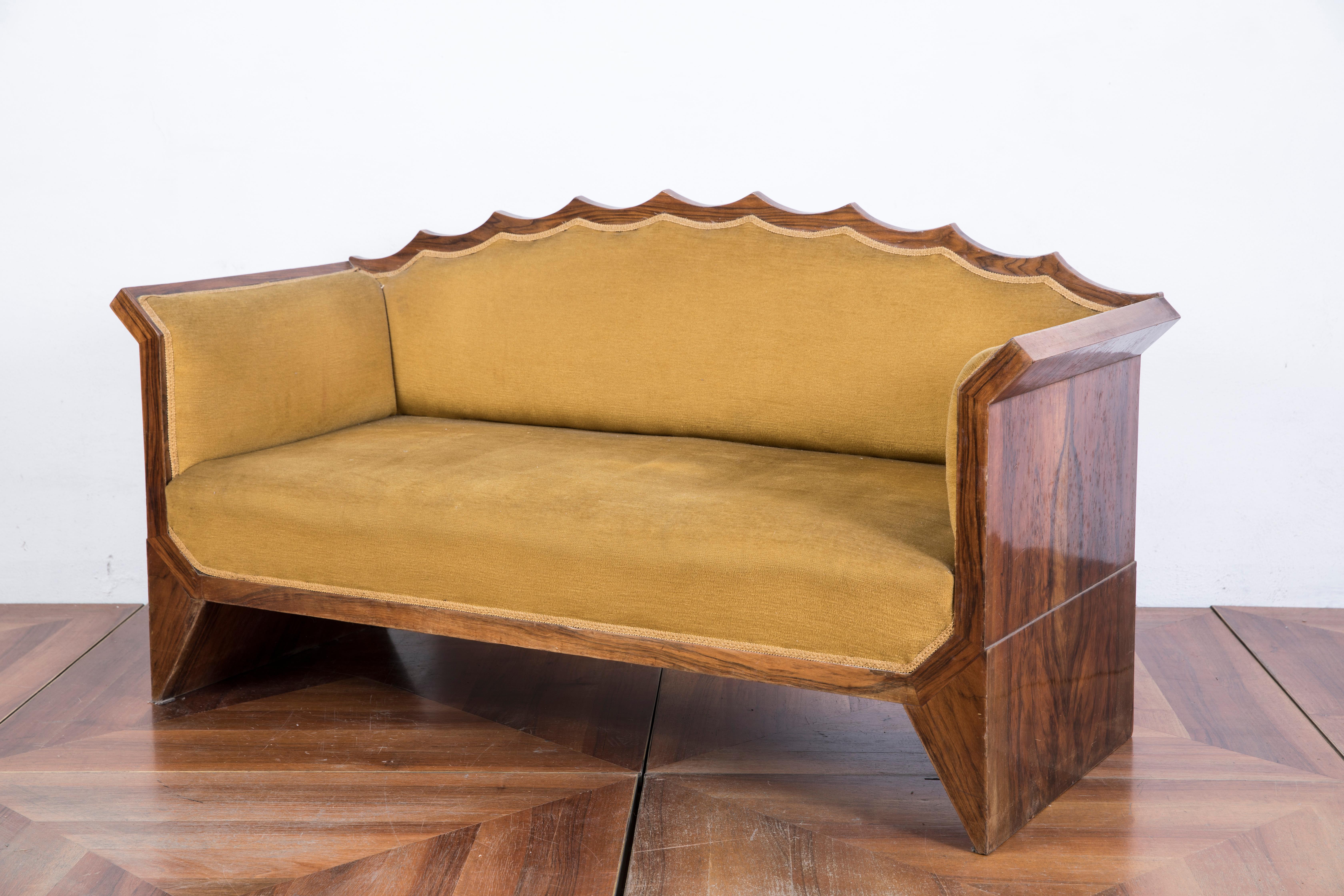 A fine period example of Austrian Art Deco design, with incurved padded back and seat, surrounded by a scalloped frame with a wavy wood crest and triangle shaped legs. The sofa is in solid wood black walnut veneered.