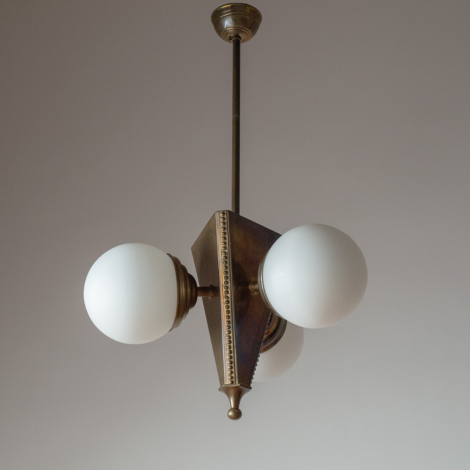 Fine Austrian Art Deco or Jugendstil chandelier in brass with satin glass globes. Designed in the early 20th century, this is probably a re-edition from the 1970s. Large triangular centerpiece with three satin glass diffuser. Nicely detailed with