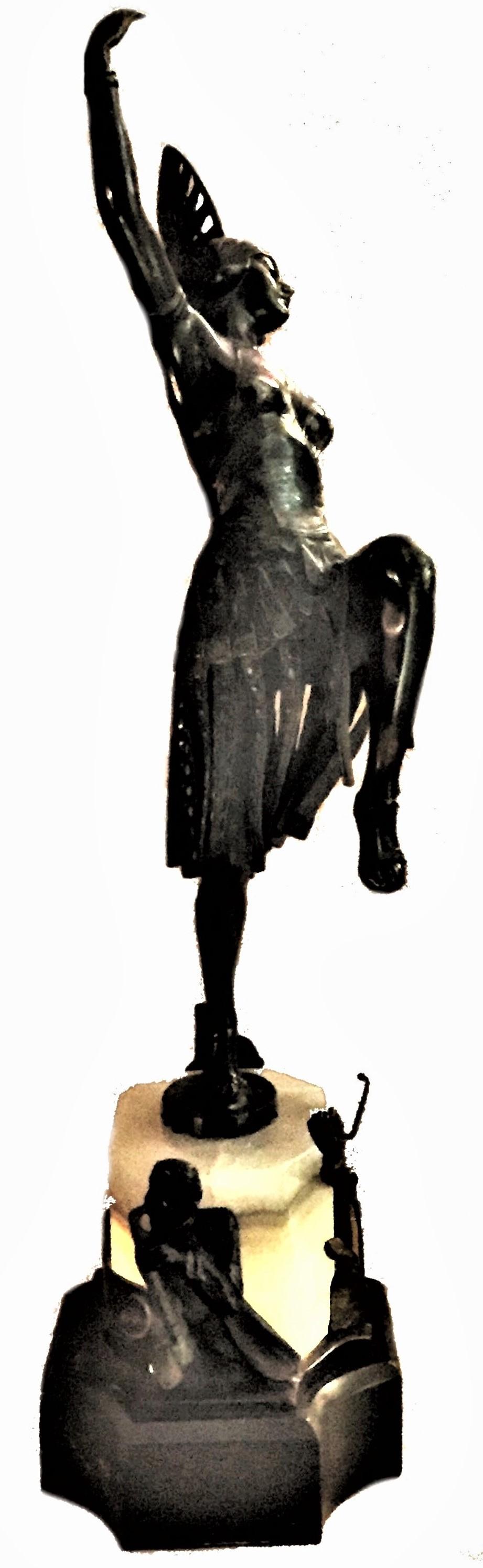 Une belle et très inhabituelle lampe de chevet Art Déco autrichienne avec une danseuse exotique semi-nue dans une coiffe de luxe. La base de la lampe est faite d'une combinaison de marbre noir et d'onyx, la partie en onyx de la base étant illuminée.