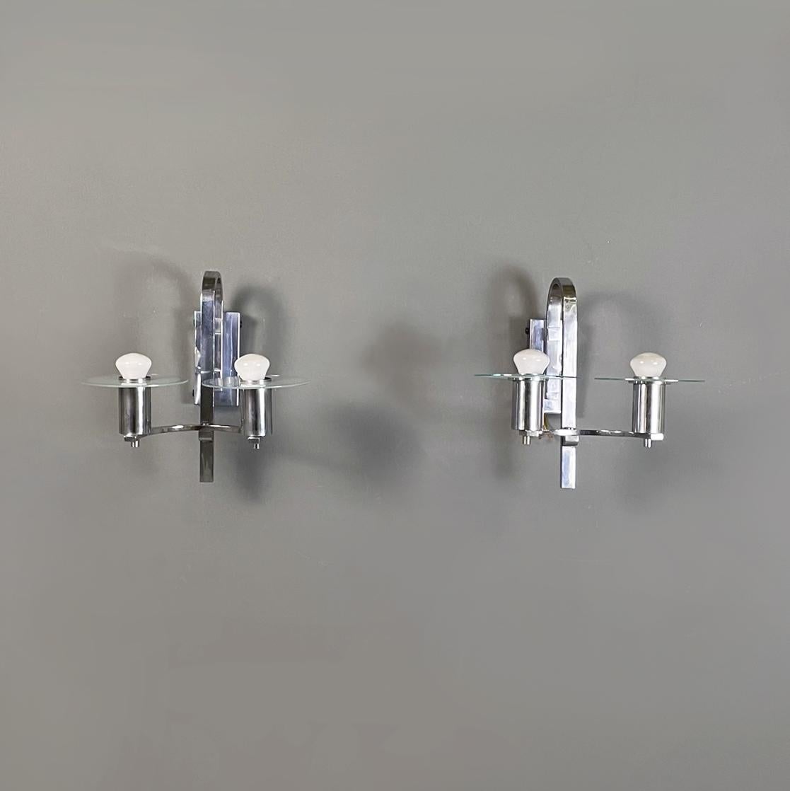 Austrian Art Deco Double light sconces in metal and glass, 1920s
Pair of double light sconces in metal and glass. The chromed metal structure is made up of two curved arms with a rectangular section, on which the two cylindrical diffusers rest. In