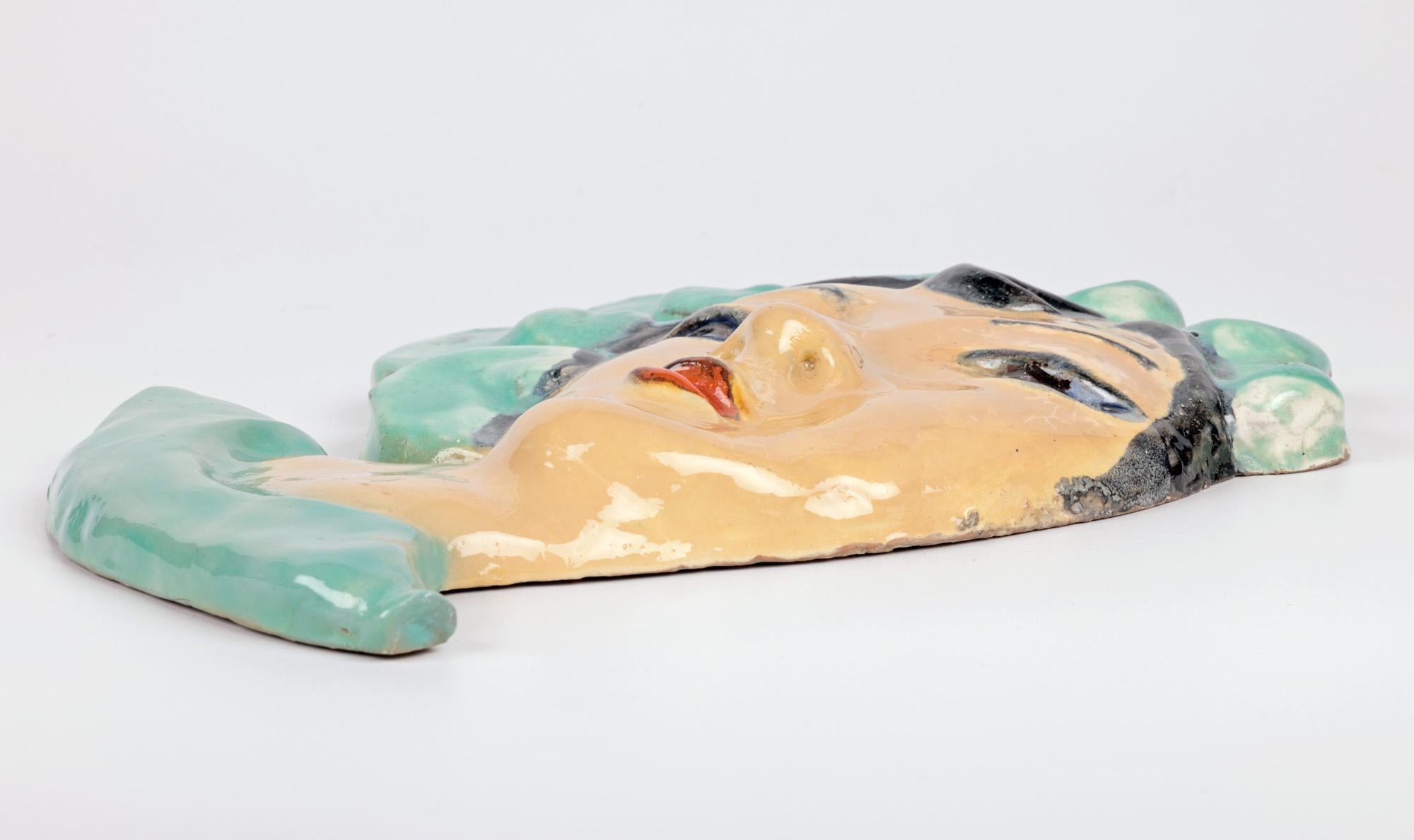 Eine stilvolle und ungewöhnliche österreichische/tschechische Art-Deco-Keramik-Gesichtsmaske einer Dame, die Walter Bosse in der Art der Wiener Werkstätte zugeschrieben wird, aus der Zeit um 1930. Die aus rotem Terrakotta-Ton gefertigte Maske stellt