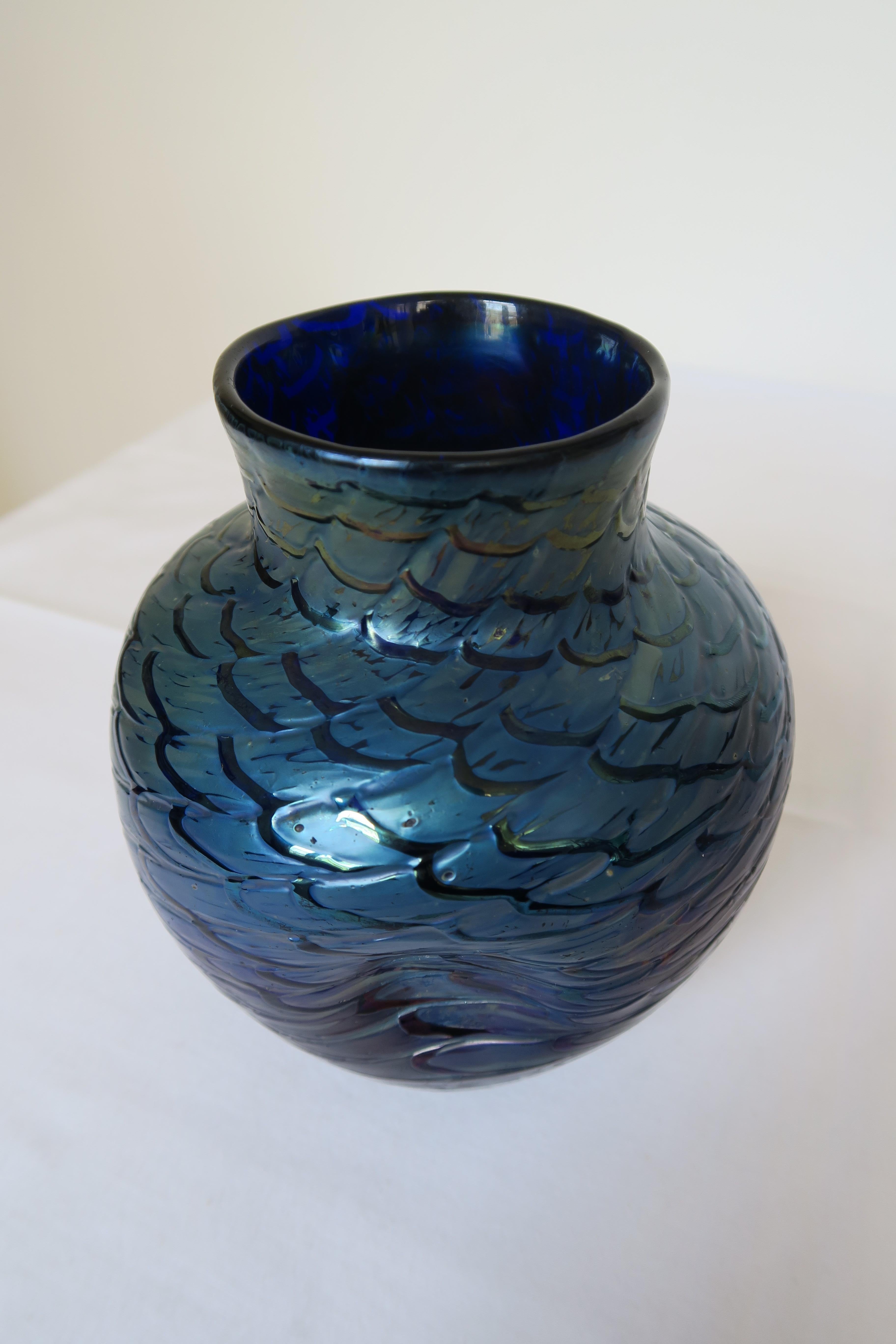 For sale in this advertisement is a very special object. It is a glass vase, crafted in Bohemia between 1905 and 1910. It shimmers in cobalt blue and silver-yellow glass. The clear, colourless glass-fibers diagonally woven around the vase make it