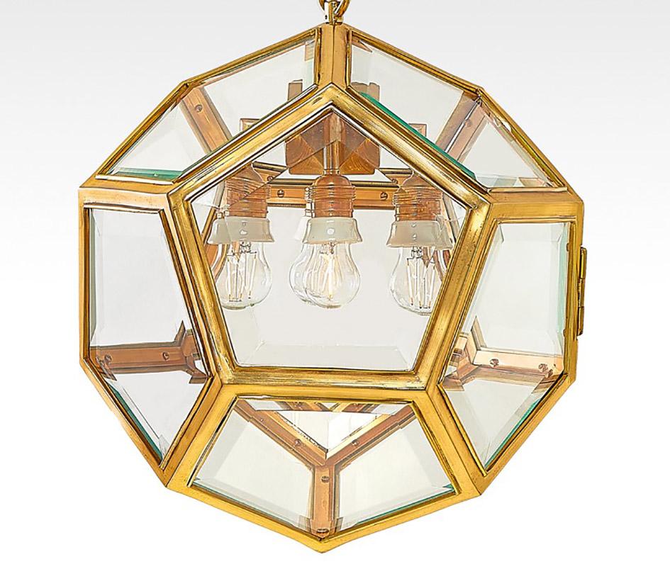 Originale e rara lampada a sospensione Dodekaeder in ottone in stile Art Nouveau viennese, disegnata da Adolf Loos e prodotta nel 1900 circa da Friedrich Otto Schmidt.
Presenta un bellissimo vetro pentagonale sfaccettato e quattro prese per