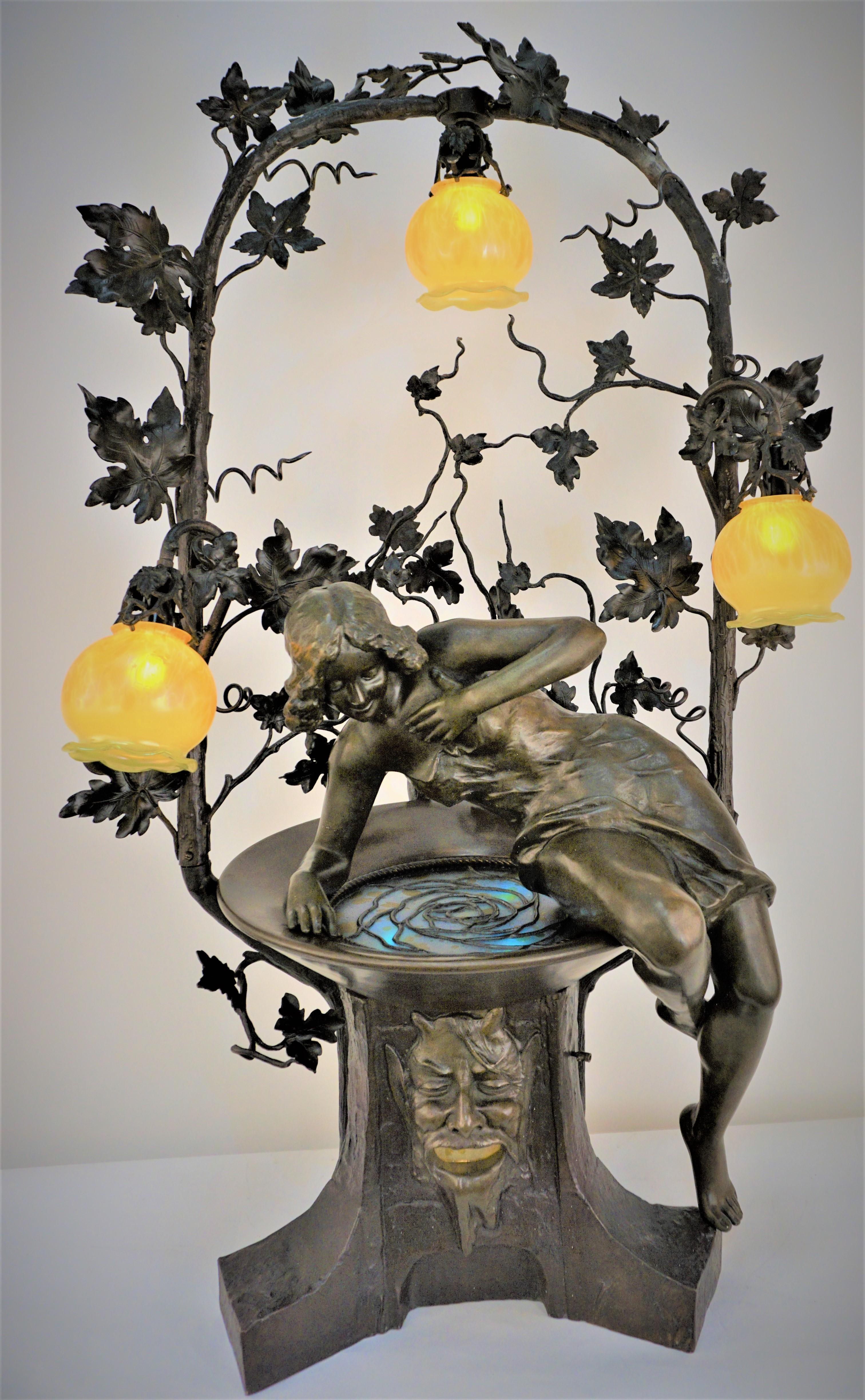 Atemberaubende große Jugendstil-Bronze-Wasser-Brunnen Kunst Glas Tischlampe.
Sie betrachtet ihr Bild im Wasser (Kunstglas mit Licht darunter).
Sockel mit Fächergesicht mit geöffnetem Mund und Lichtreflexion durch Kunstglas.