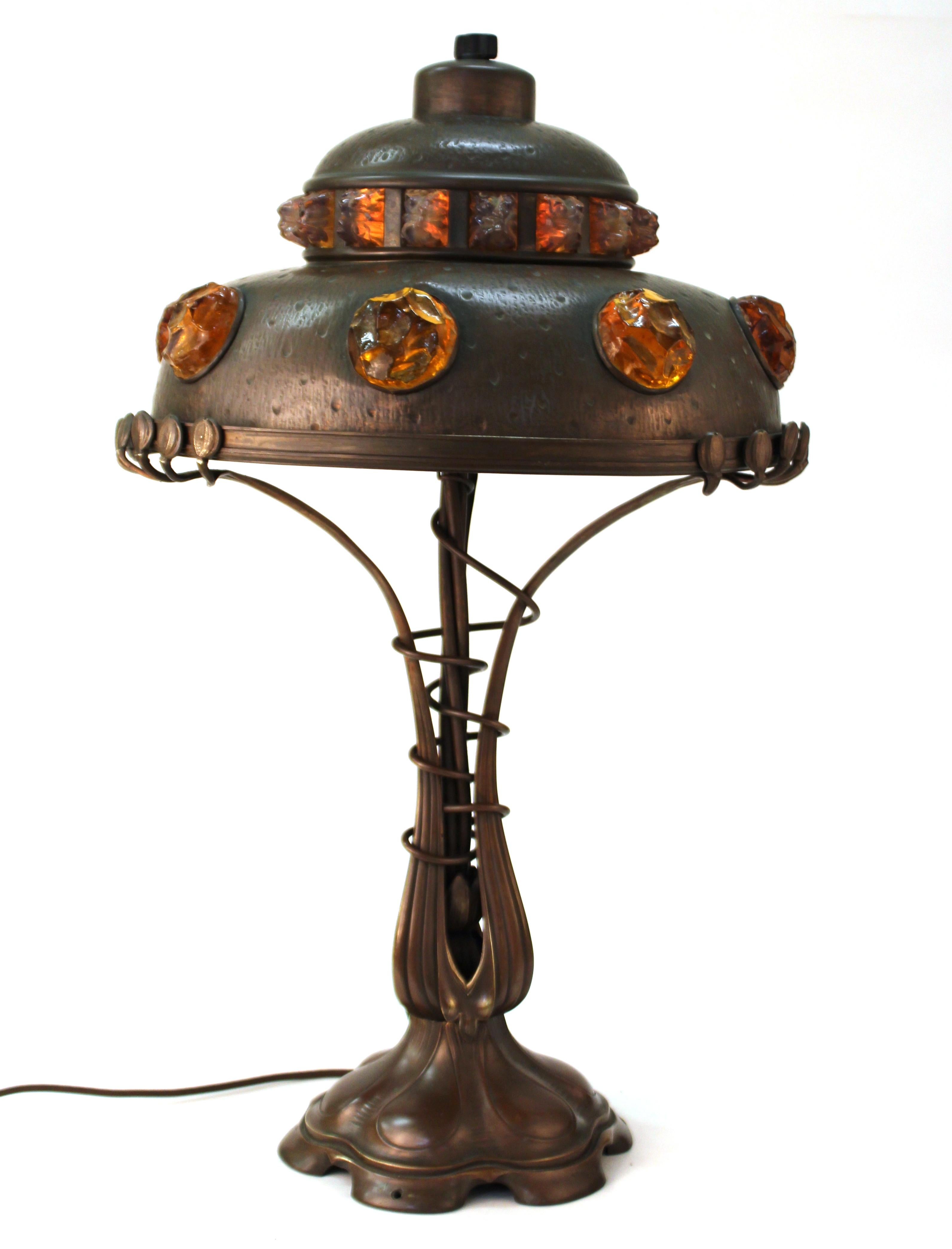 Lampe de table autrichienne d'époque Art Nouveau en fonte de bronze et laiton repoussé, avec des bijoux en verre chunk insérés dans l'abat-jour. La pièce a été fabriquée en Autriche dans les années 1900 et a été recâblée. Il fonctionne avec trois