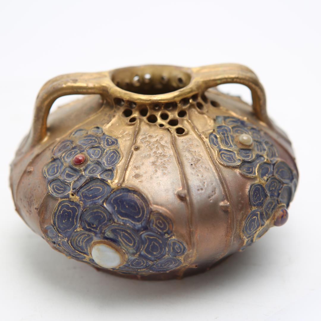Austrian Art Nouveau Amphora-shaped gilt pottery ovoid vase with incised blue flowers on the sides, each one centered around a cabochon, and with a pierced rim. The piece is marked underneath. In great vintage condition with minor age-appropriate