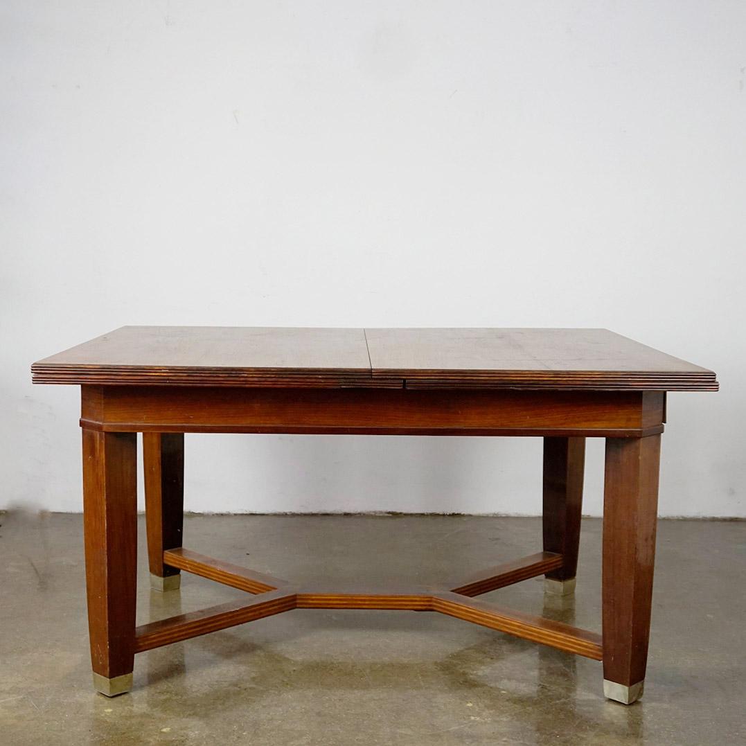 This Viennese Art Nouveau Extendable dining table was manufactured  by the cabinetmaker August Ungethüm  ca 1905 in Vienna AUstria.
It is made with excellent craftmanship with striking details as brass shoes and  Boxwood bandwork marquetry decorated
